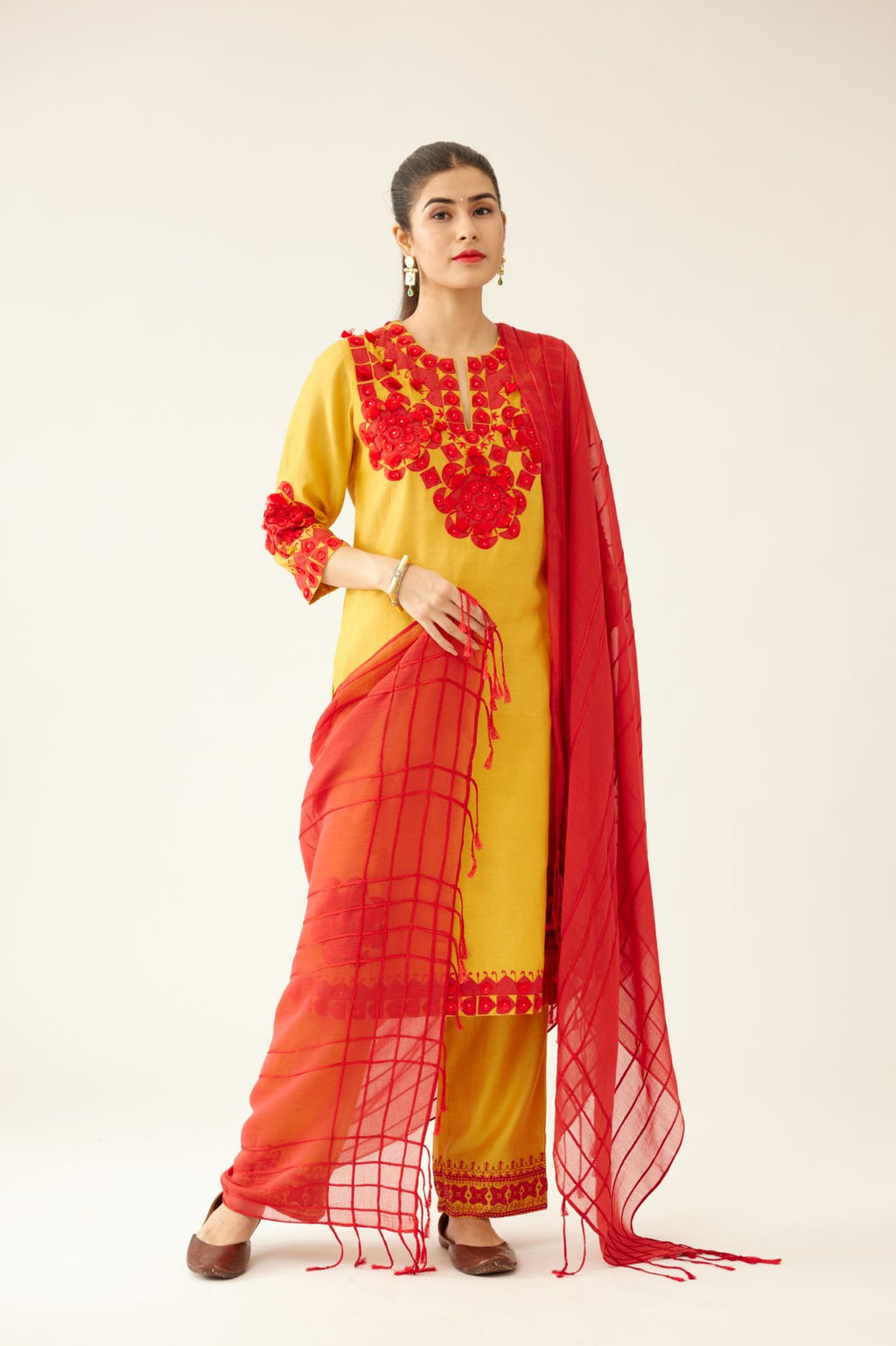Golden yellow silk chanderi mid length straight kurta set, highlighted with all-over contrast applique, tassels and sequins.