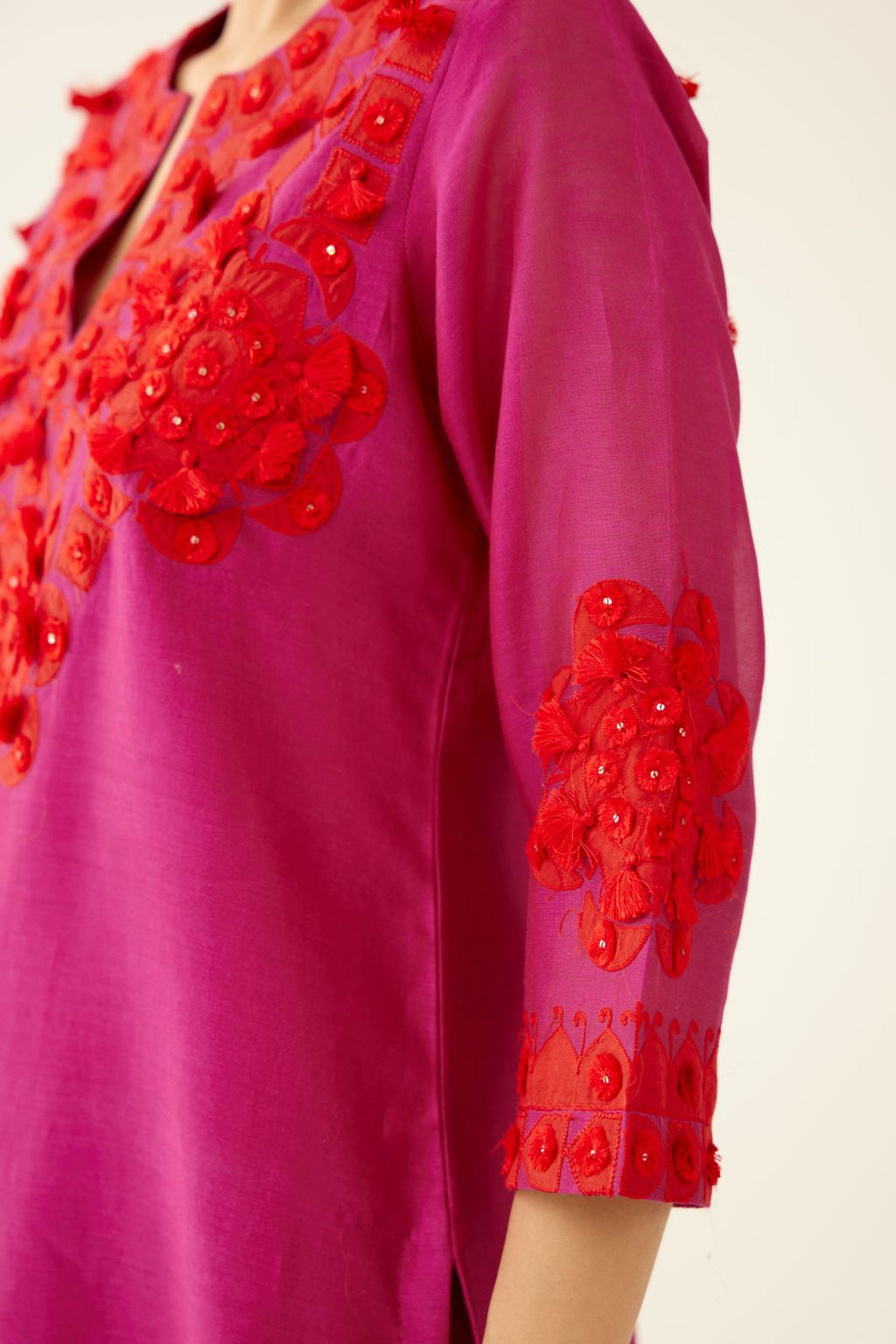 Fuchsia silk chanderi mid length straight kurta set, highlighted with all-over contrast applique, tassels and sequins.