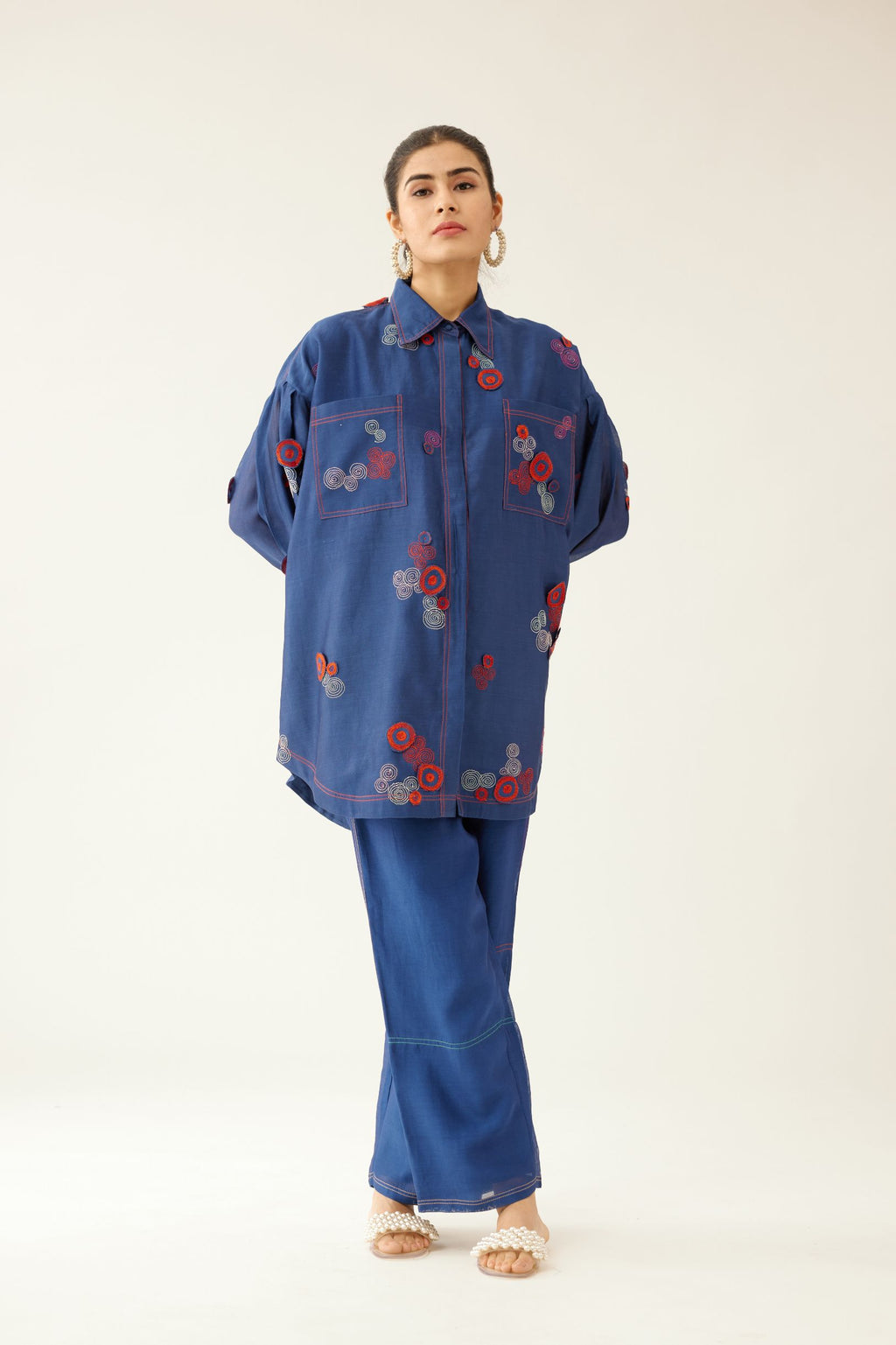 Blue silk chanderi easy fit shirt with shirt collar neckline and multi colored 3D spiral embroidery, paired with blue silk chanderi straight pants, highlighted with multi colored thread stitch detail.