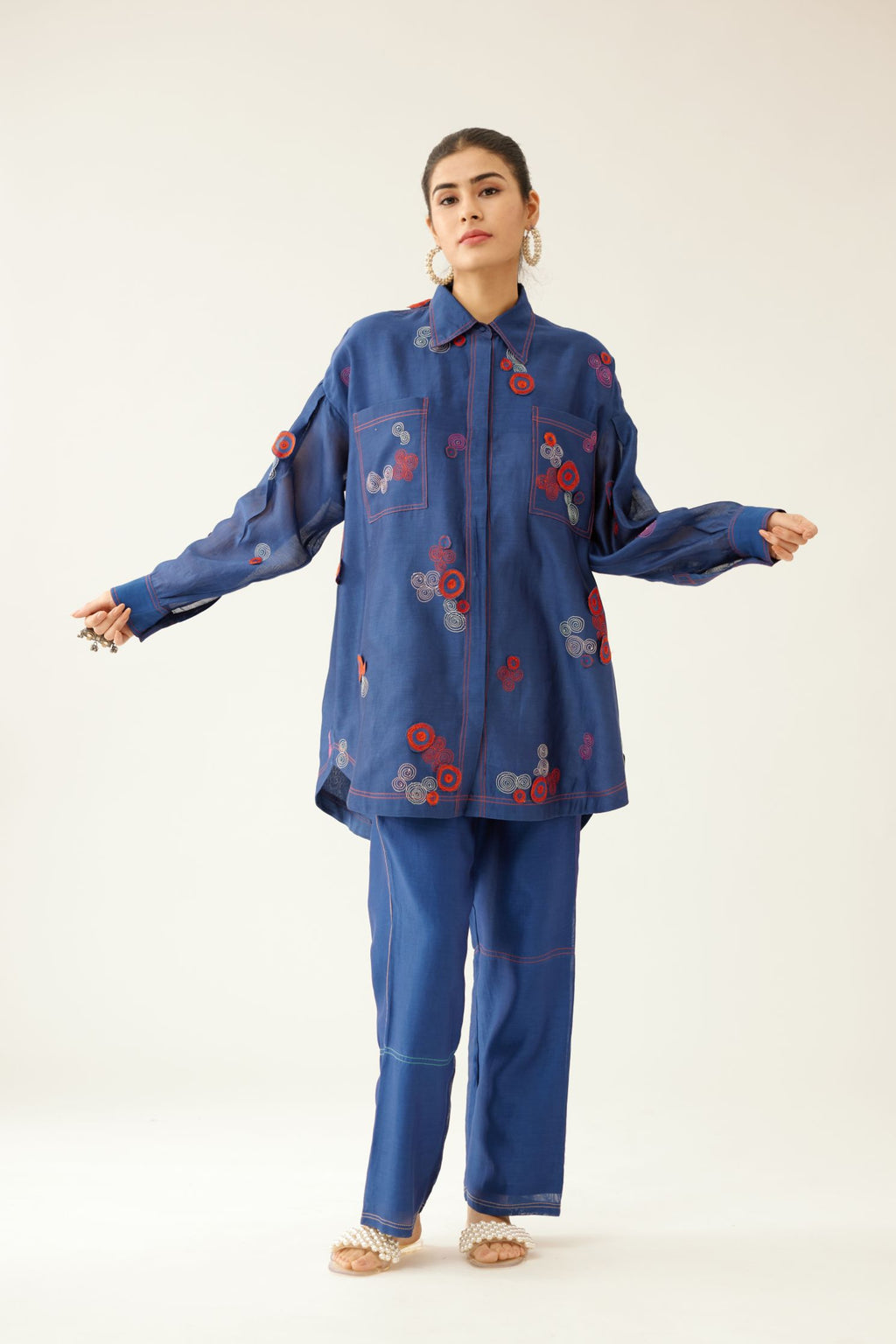 Blue silk chanderi easy fit shirt with shirt collar neckline and multi colored 3D spiral embroidery, paired with blue silk chanderi straight pants, highlighted with multi colored thread stitch detail.