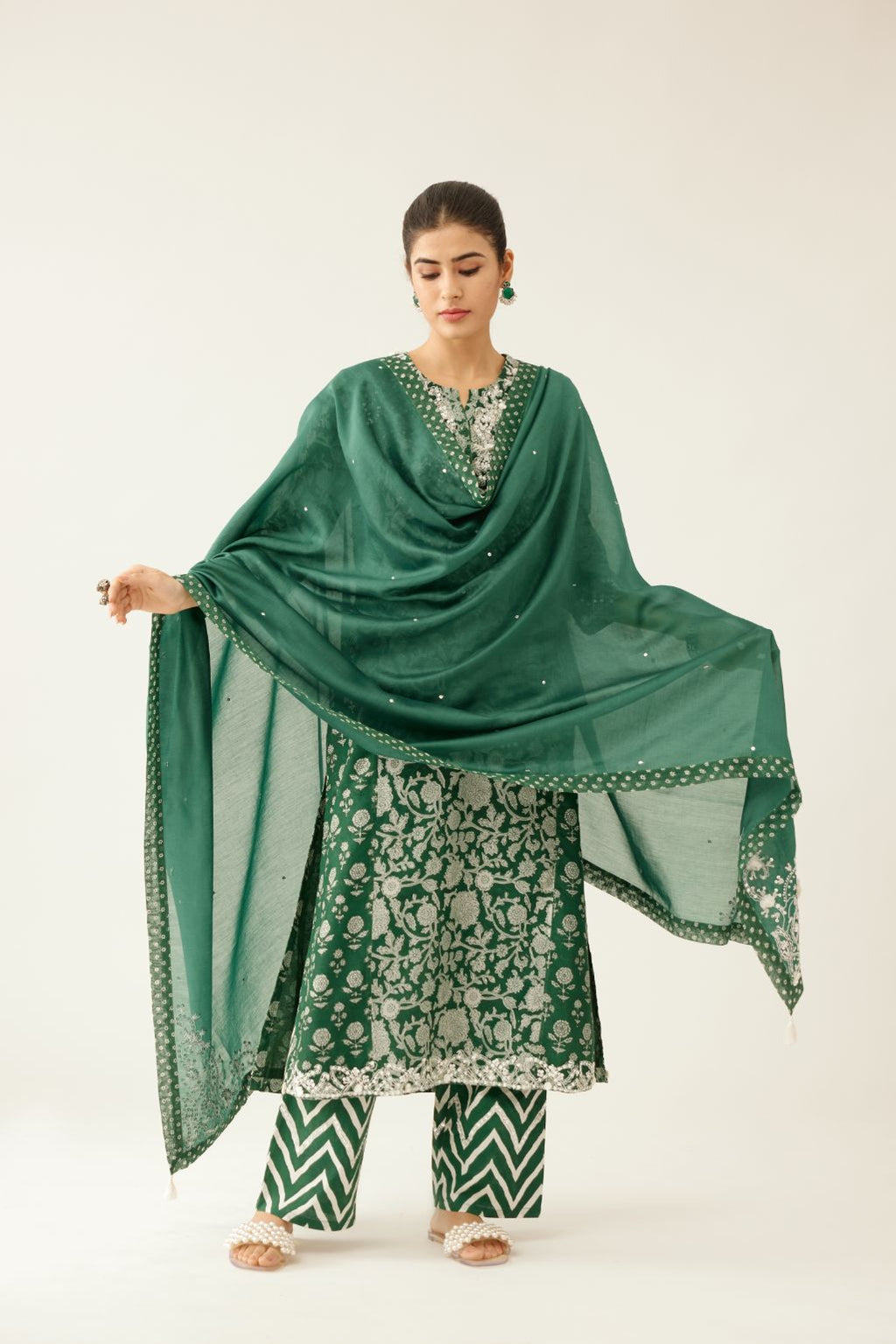 Green silk chanderi dupatta highlighted with sequin, tassels and bead work boota at corners and printed border running along all edges.