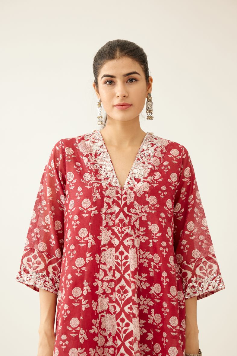 Red hand block printed kurta dress set with a V neck, detailed with sequin, tassels and bead work.