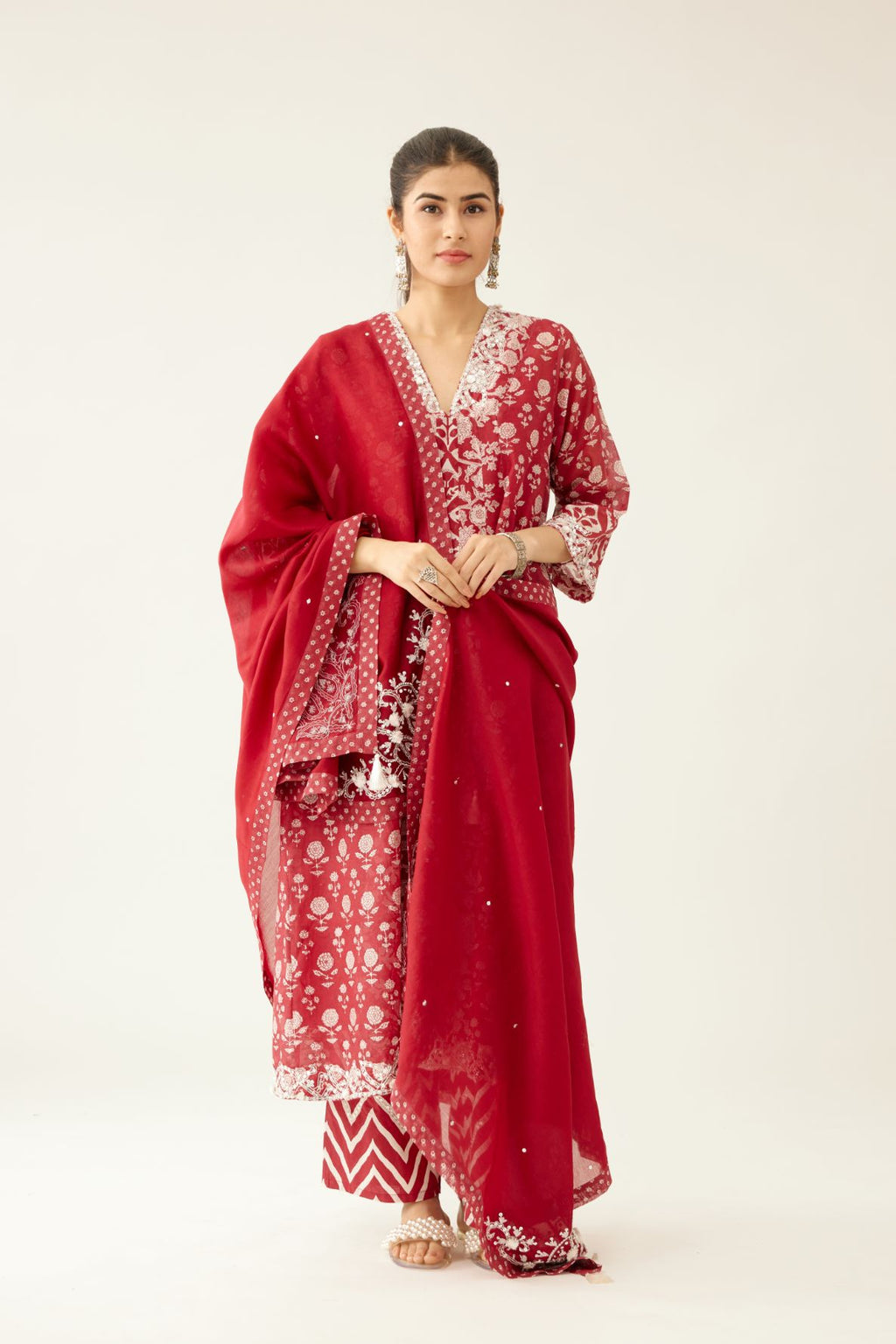 Red silk chanderi dupatta highlighted with sequin, tassels and bead work boota at corners and printed border running along all edges.