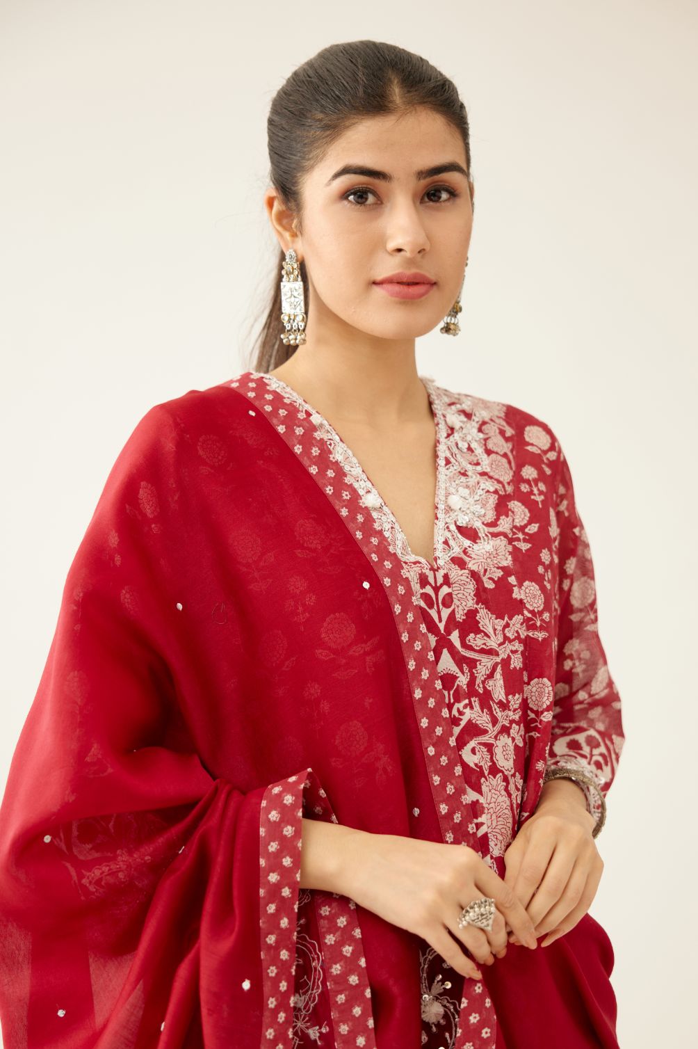 Red silk chanderi dupatta highlighted with sequin, tassels and bead work boota at corners and printed border running along all edges.