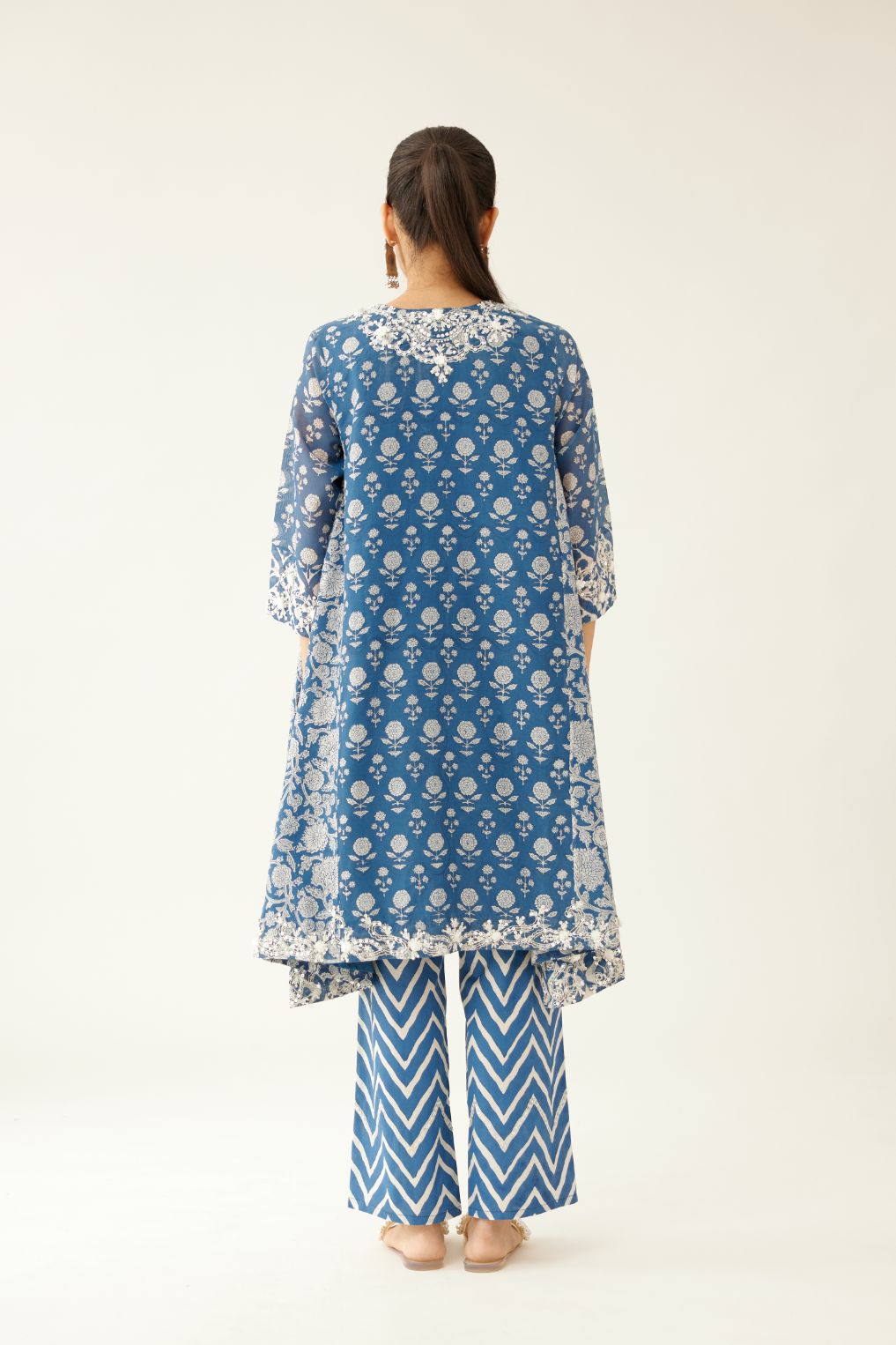 Blue hand block printed short kalidar kurta set highlighted with sequins, tassels and bead work.