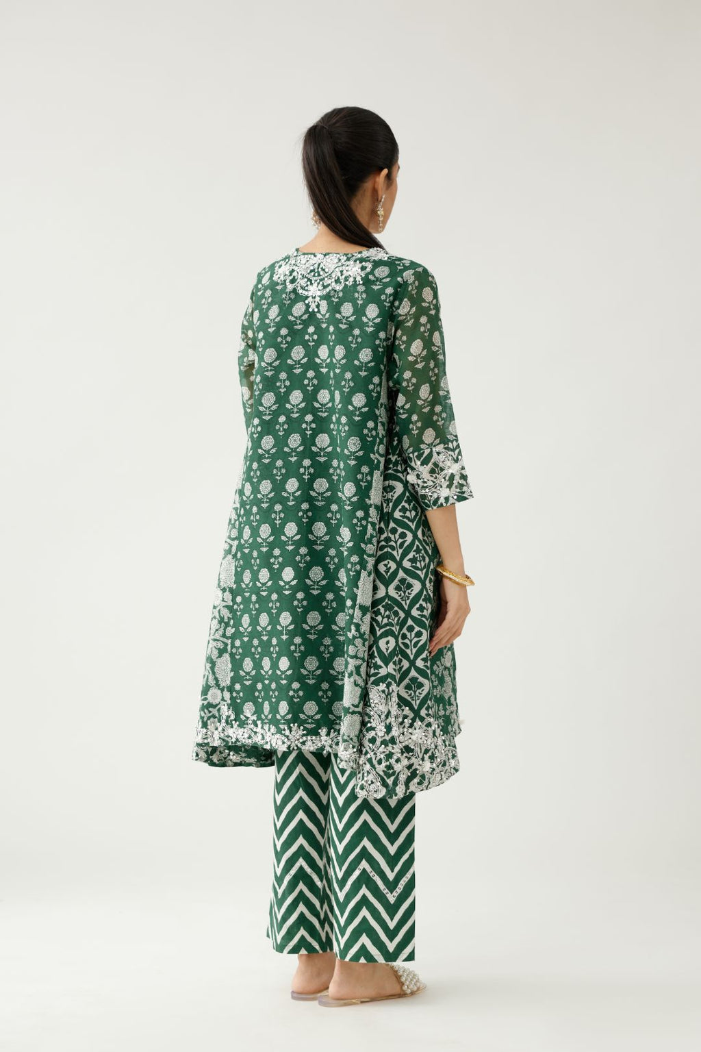 Green hand block printed short kalidar kurta set highlighted with sequins, tassels and bead work.