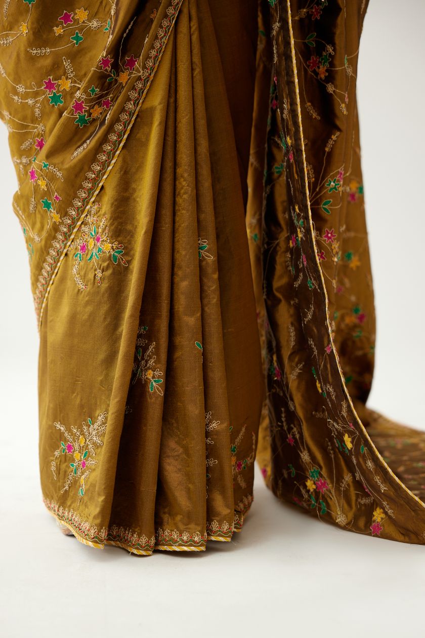 Golden olive silk saree set, detailed with all over delicate dori and silk thread embroidery work, paired with raspberry silk blouse with princess seams and all-over delicate dori and silk thread embroidered.
