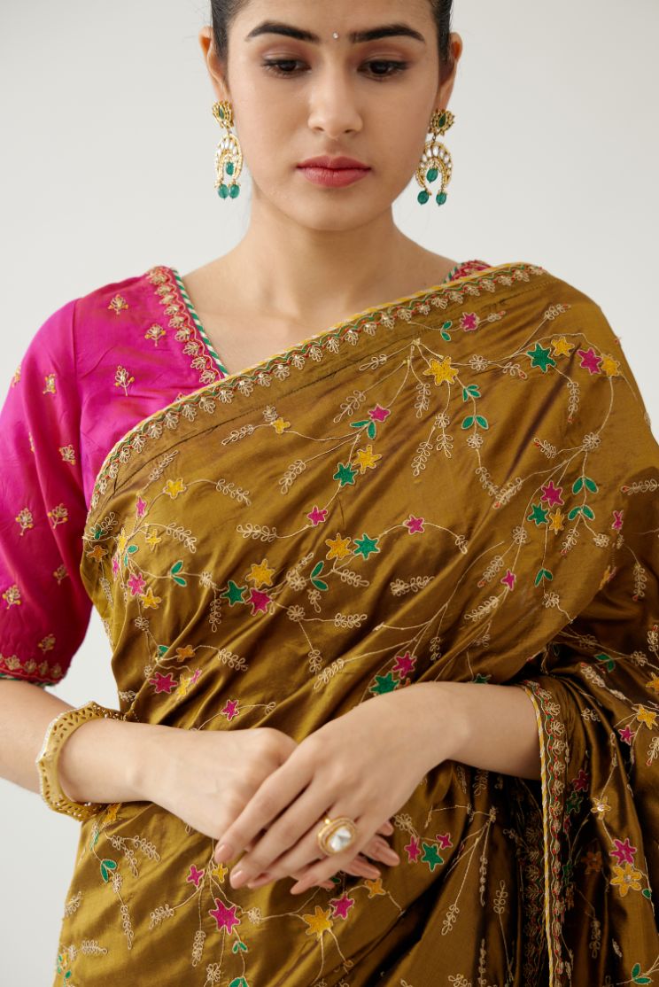 Golden olive silk saree set, detailed with all over delicate dori and silk thread embroidery work, paired with raspberry silk blouse with princess seams and all-over delicate dori and silk thread embroidered.