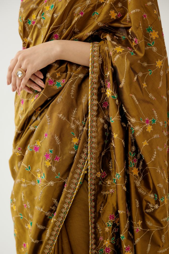 Golden olive silk saree set, detailed with all over delicate dori and silk thread embroidery work, paired with raspberry silk blouse with princess seams and all-over delicate dori and silk thread embroidered.