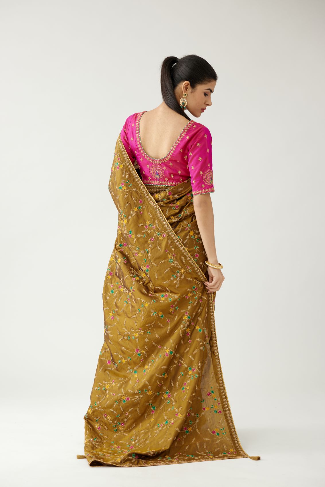 Golden olive silk saree set, detailed with all over delicate dori and silk thread embroidery work, paired with raspberry silk blouse with princess seams and all-over delicate dori and silk thread embroidered.