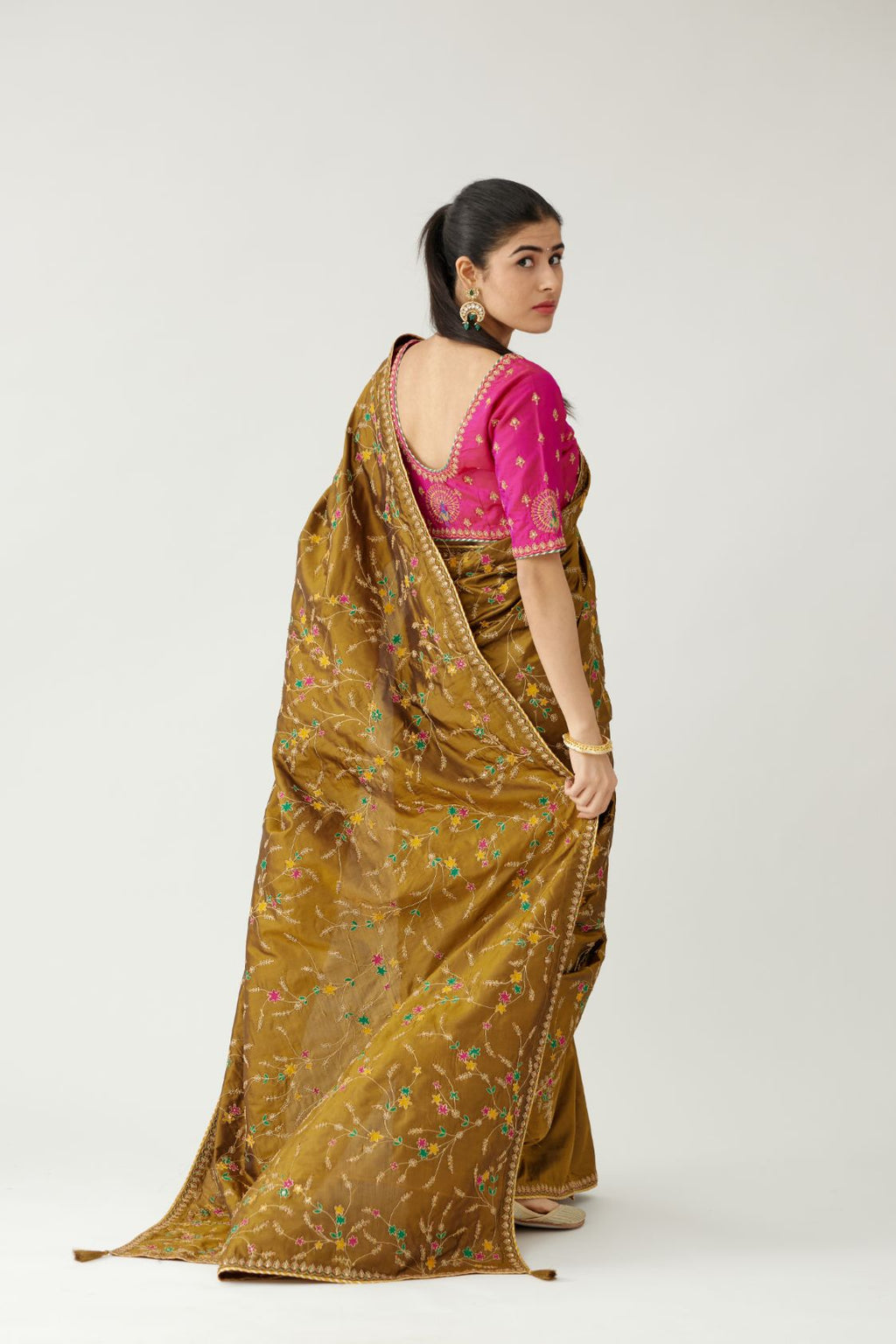 Golden olive silk saree set, detailed with all over delicate dori and silk thread embroidery work, paired with raspberry silk blouse with princess seams and all-over delicate dori and silk thread embroidered.