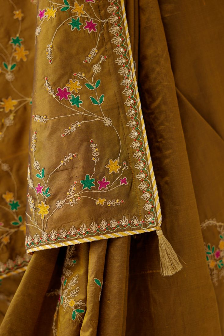 Golden olive silk saree set, detailed with all over delicate dori and silk thread embroidery work, paired with raspberry silk blouse with princess seams and all-over delicate dori and silk thread embroidered.