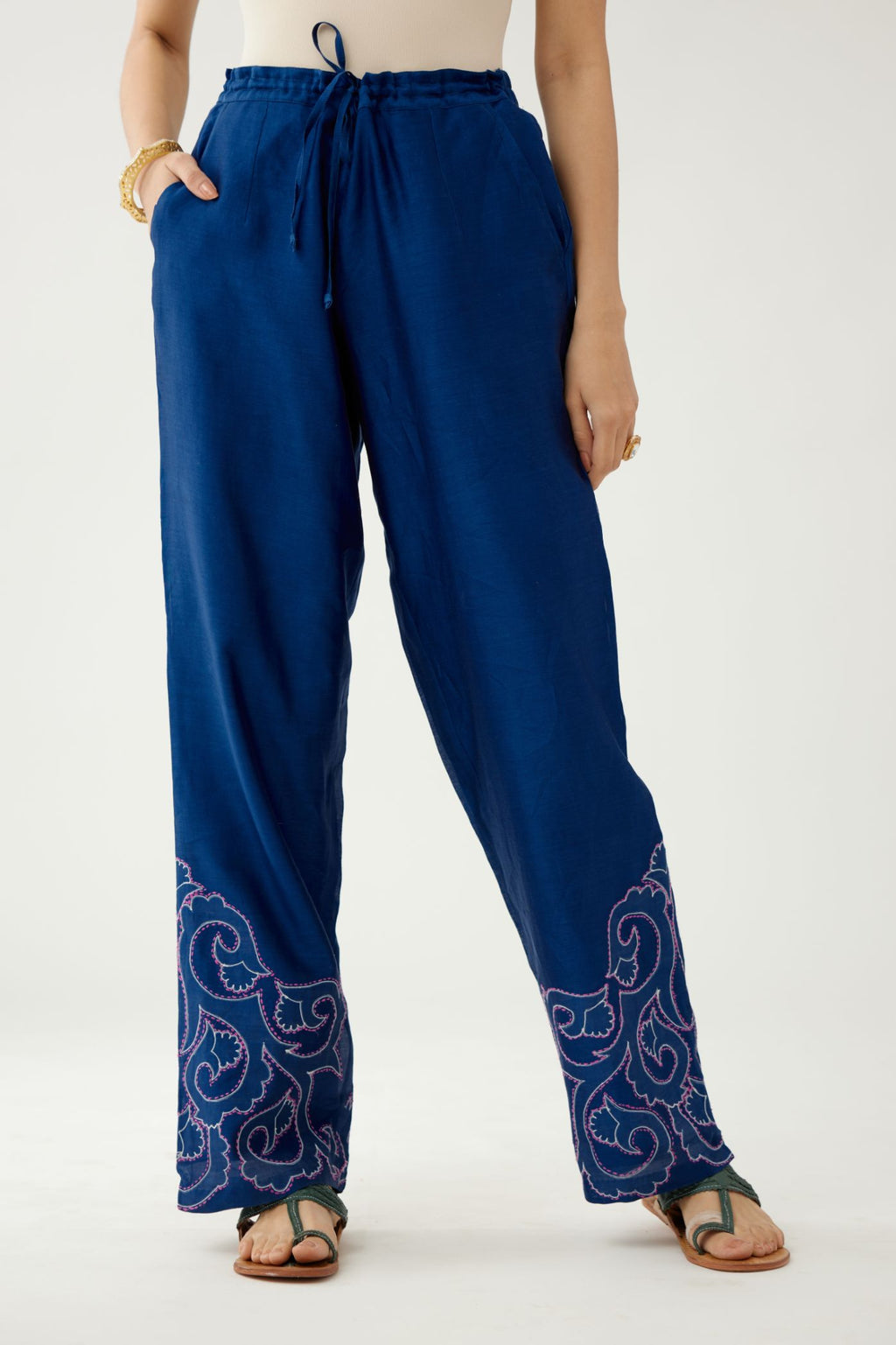 Blue silk chanderi straight pants with cotton appliqué jaal work at reverse side, highlighted with kantha work in front side at bottom hem.