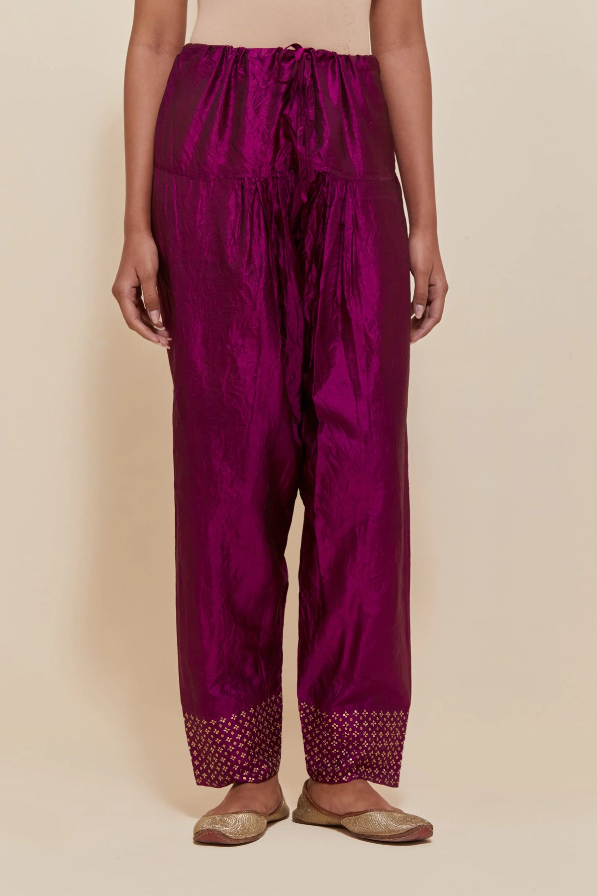 Purple silk salwar with hand-embroidered gold sequin work in a broad border at the hem.
