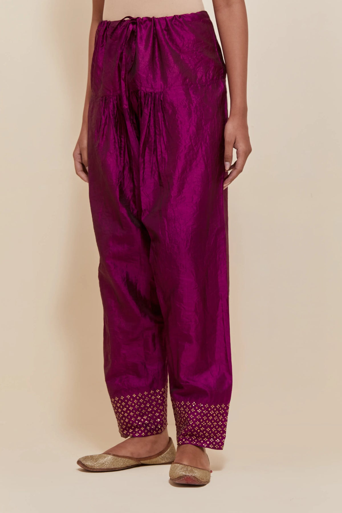 Purple silk salwar with hand-embroidered gold sequin work in a broad border at the hem.