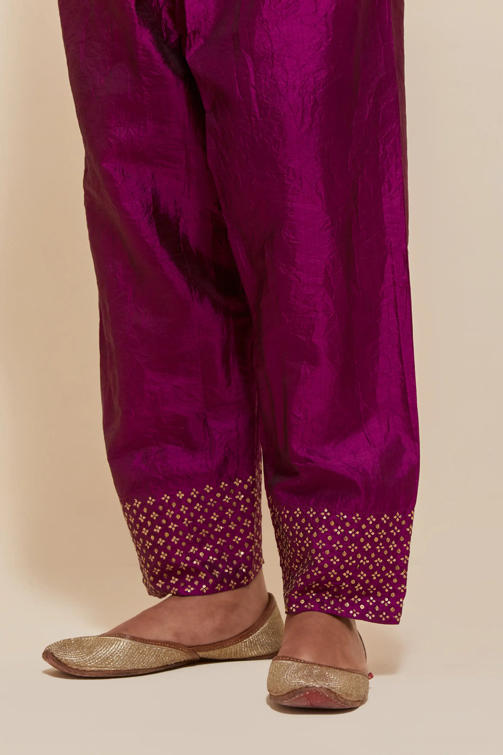 Purple silk salwar with hand-embroidered gold sequin work in a broad border at the hem.