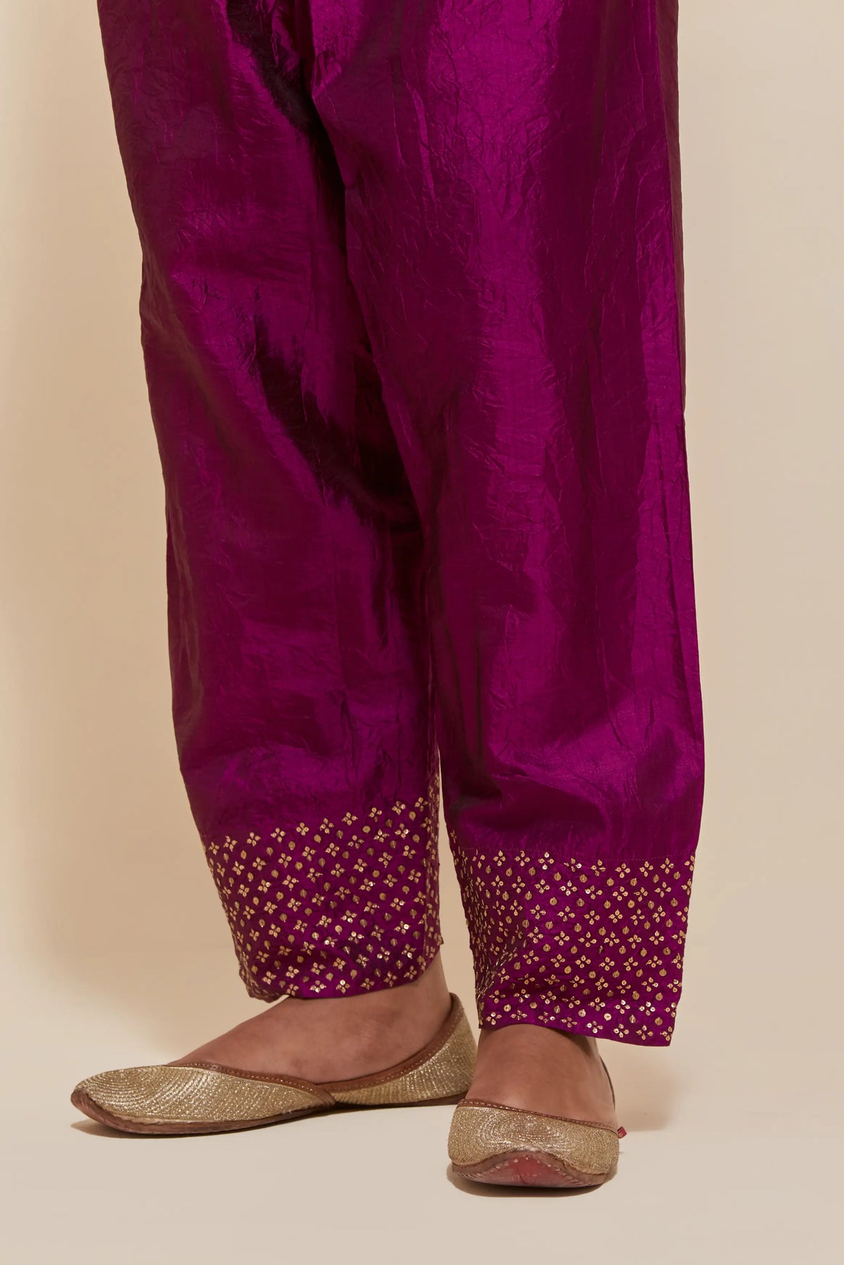 Purple silk salwar with hand-embroidered gold sequin work in a broad border at the hem.