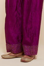 Purple silk farshi salwar with hand-embroidered gold sequin work in a broad border at the hem.