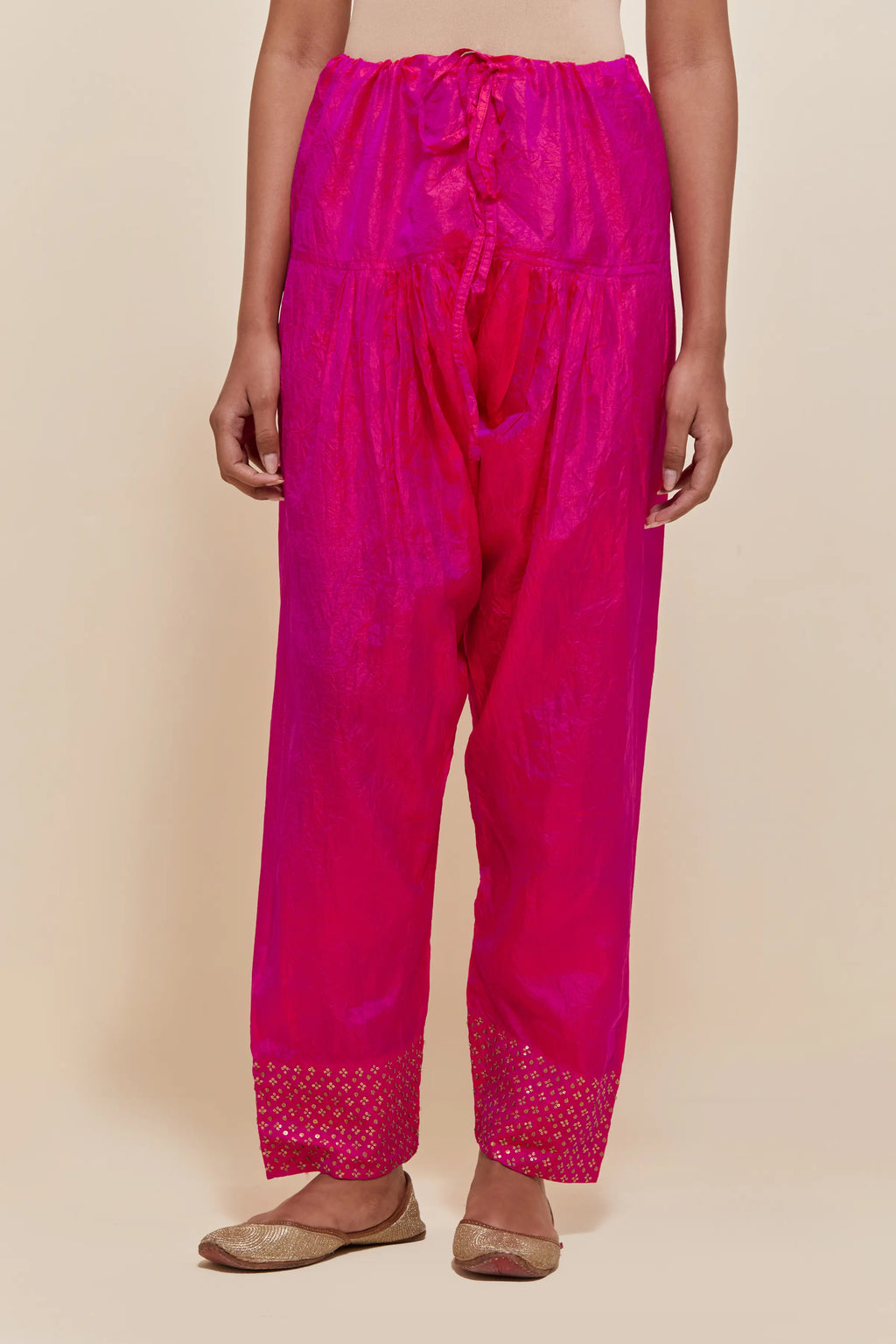 Fuchsia silk salwar with hand-embroidered gold sequin work in a broad border at the hem.
