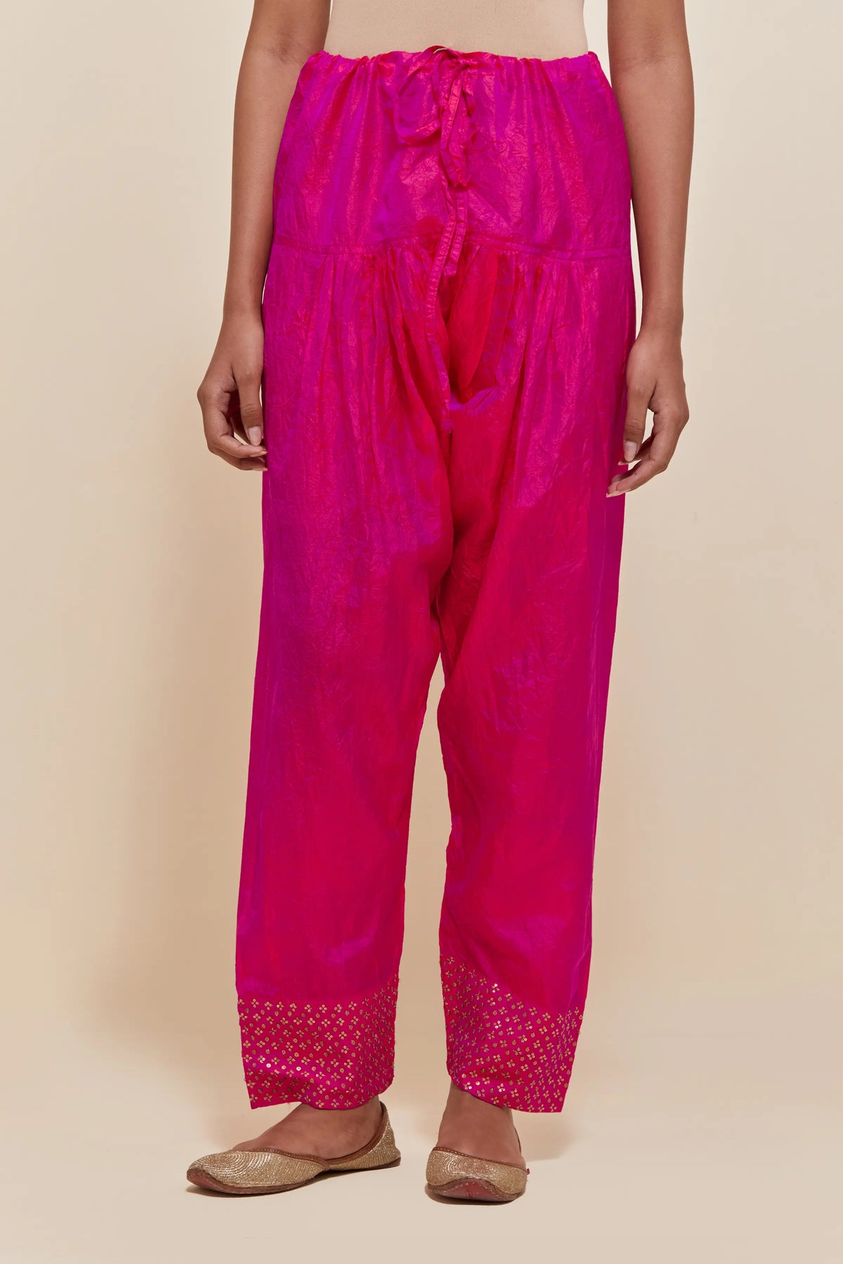 Fuchsia silk salwar with hand-embroidered gold sequin work in a broad border at the hem.