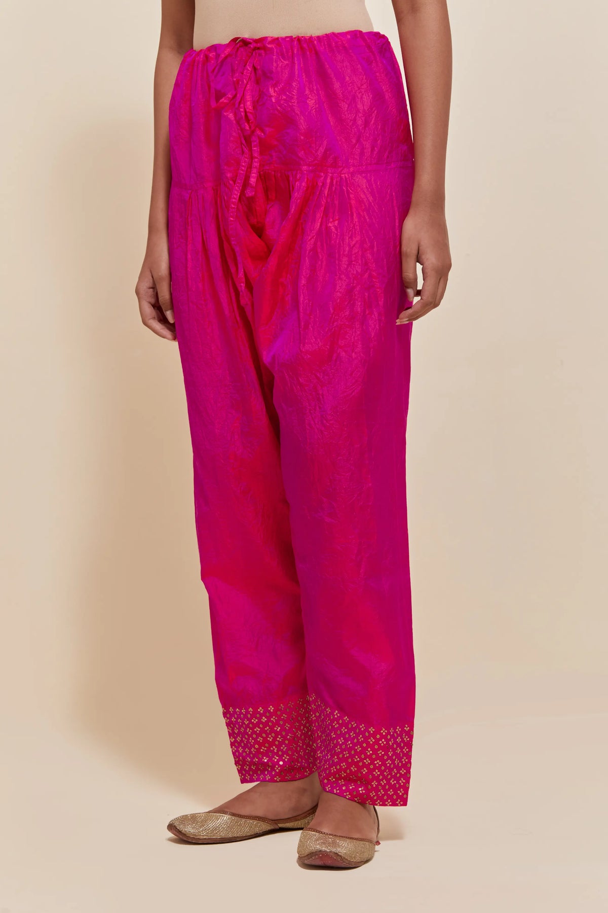 Fuchsia silk salwar with hand-embroidered gold sequin work in a broad border at the hem.