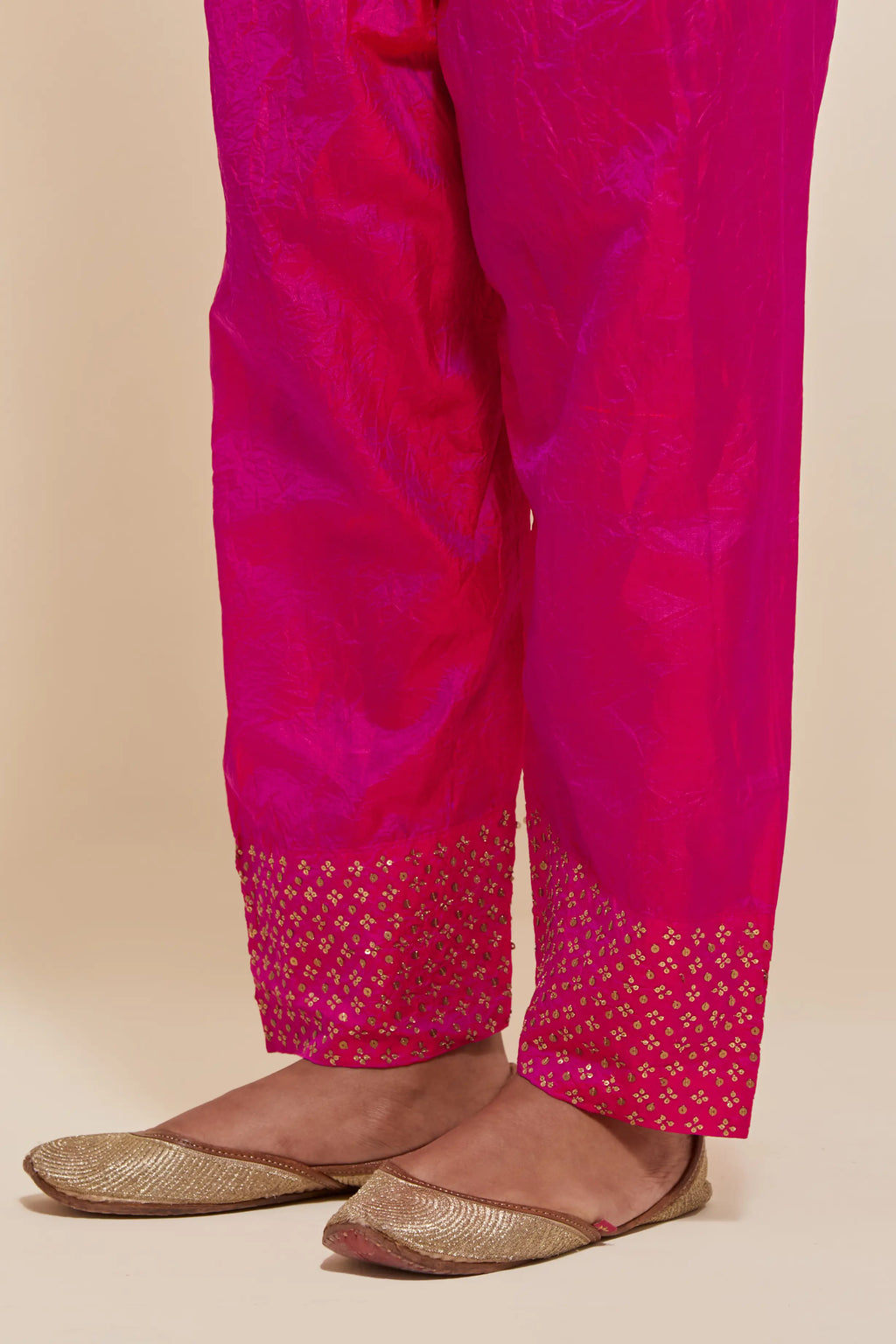 Fuchsia silk salwar with hand-embroidered gold sequin work in a broad border at the hem.