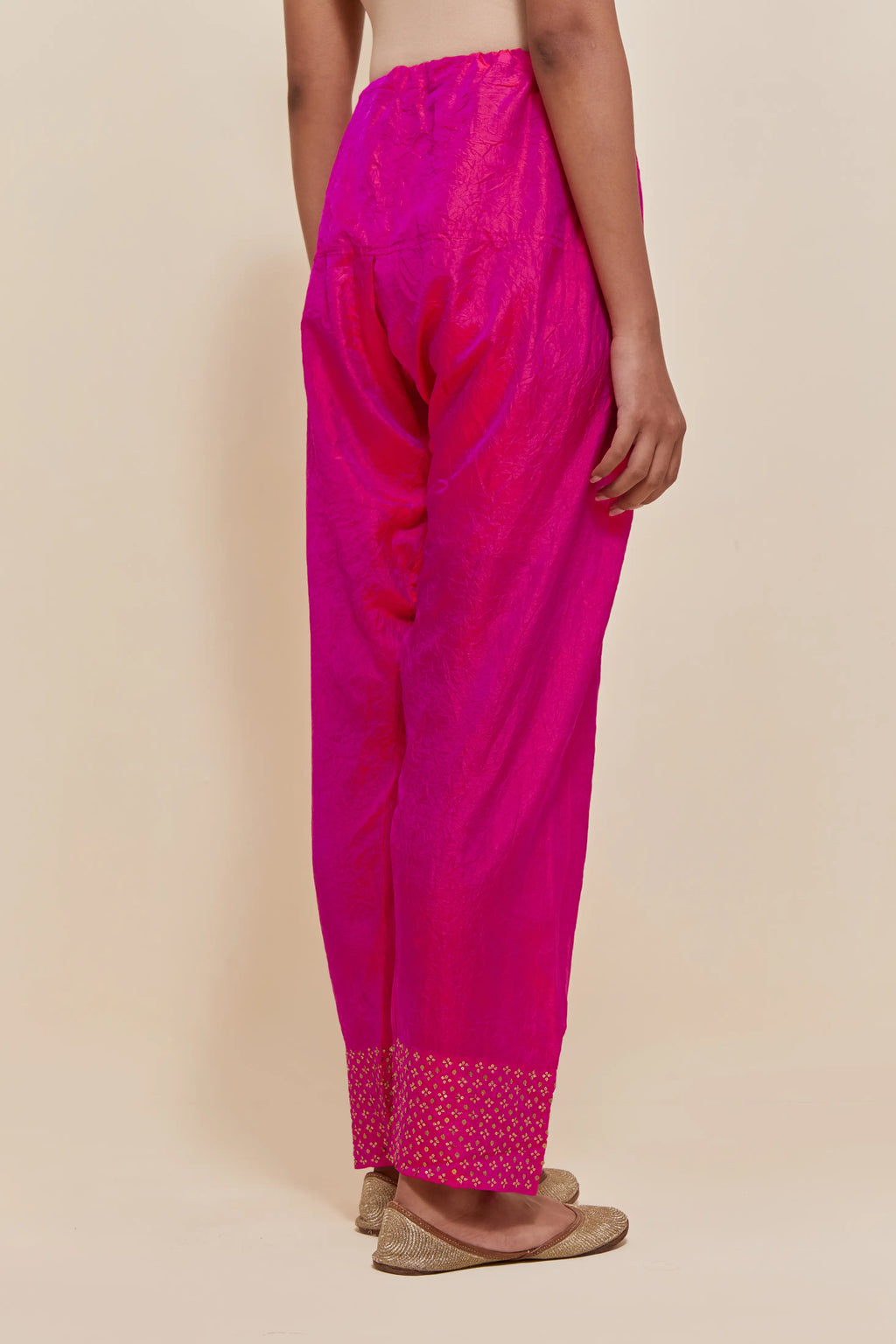 Fuchsia silk salwar with hand-embroidered gold sequin work in a broad border at the hem.