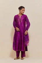 Purple silk straight kurta set with hand-embroidered paisley motifs with delicate gold sequins work at neck, hem, and sleeves, with narrow borders along the edges.
