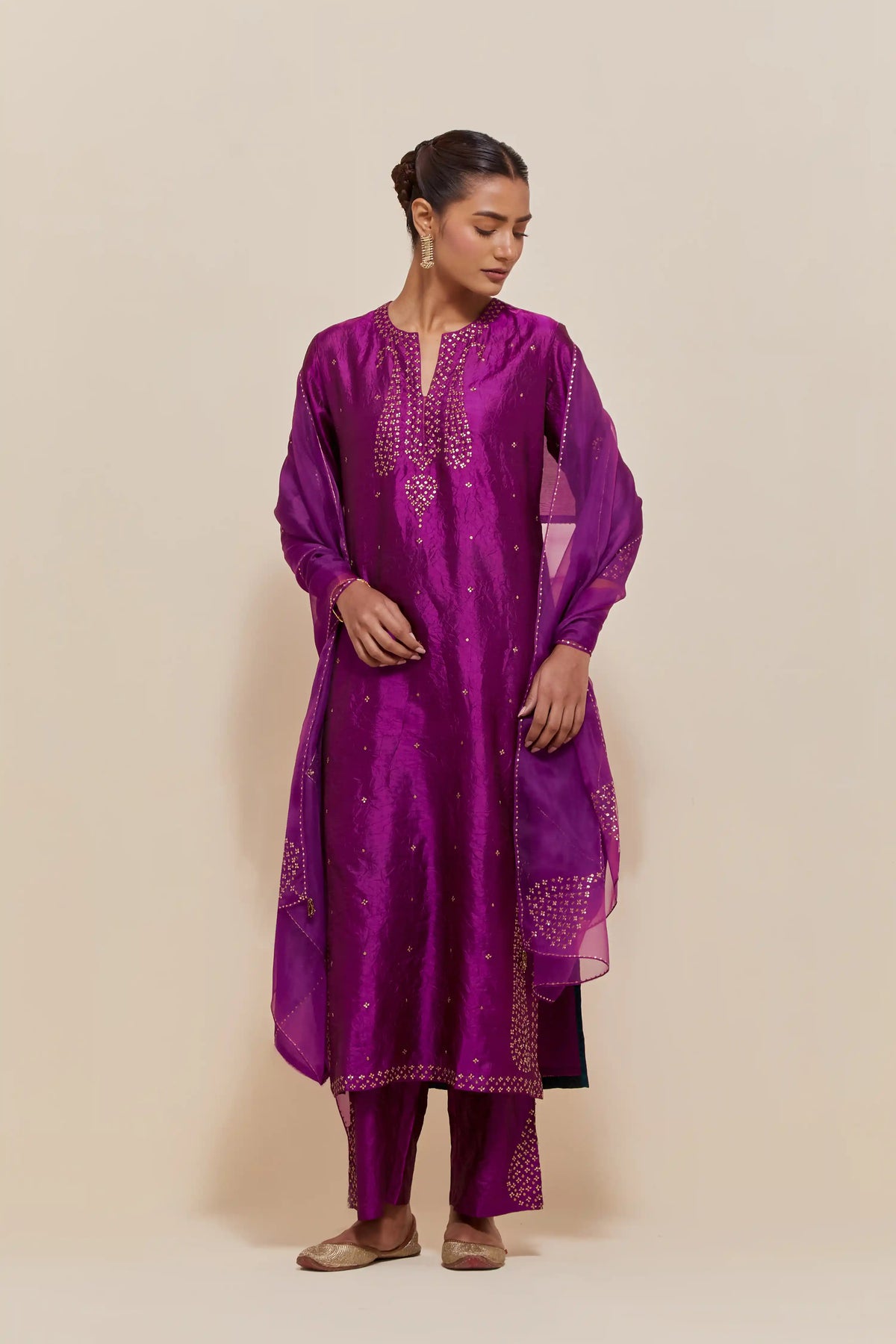 Purple silk straight kurta set with hand-embroidered paisley motifs with delicate gold sequins work at neck, hem, and sleeves, with narrow borders along the edges.