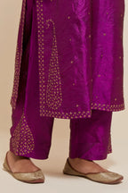 Purple silk straight kurta set with hand-embroidered paisley motifs with delicate gold sequins work at neck, hem, and sleeves, with narrow borders along the edges.