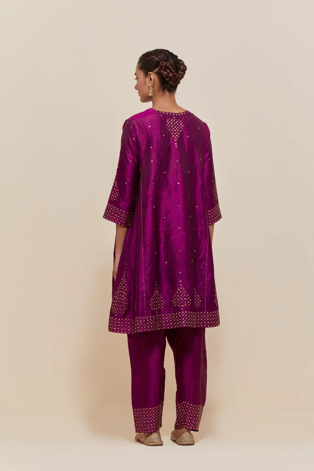 Purple silk short kalidar kurta set, with hand embroidered sequins at neck, hem and sleeve edges, highlighted with scattered gold sequins embellishments all-over.