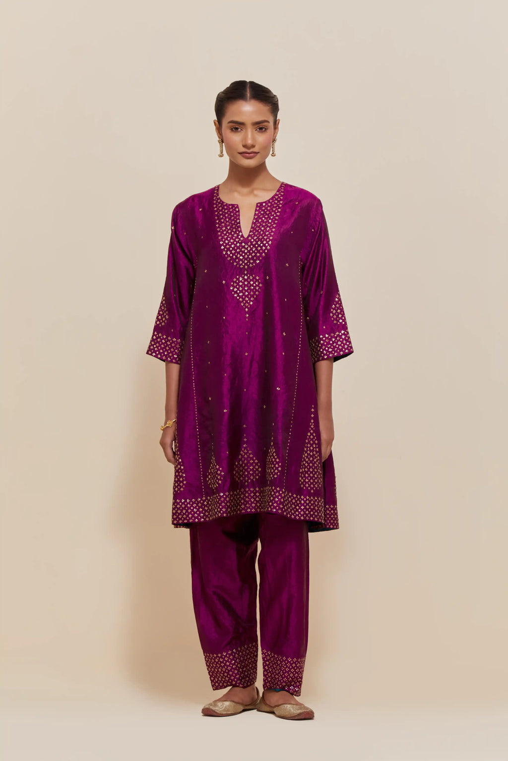 Purple silk short kalidar kurta set, with hand embroidered sequins at neck, hem and sleeve edges, highlighted with scattered gold sequins embellishments all-over.