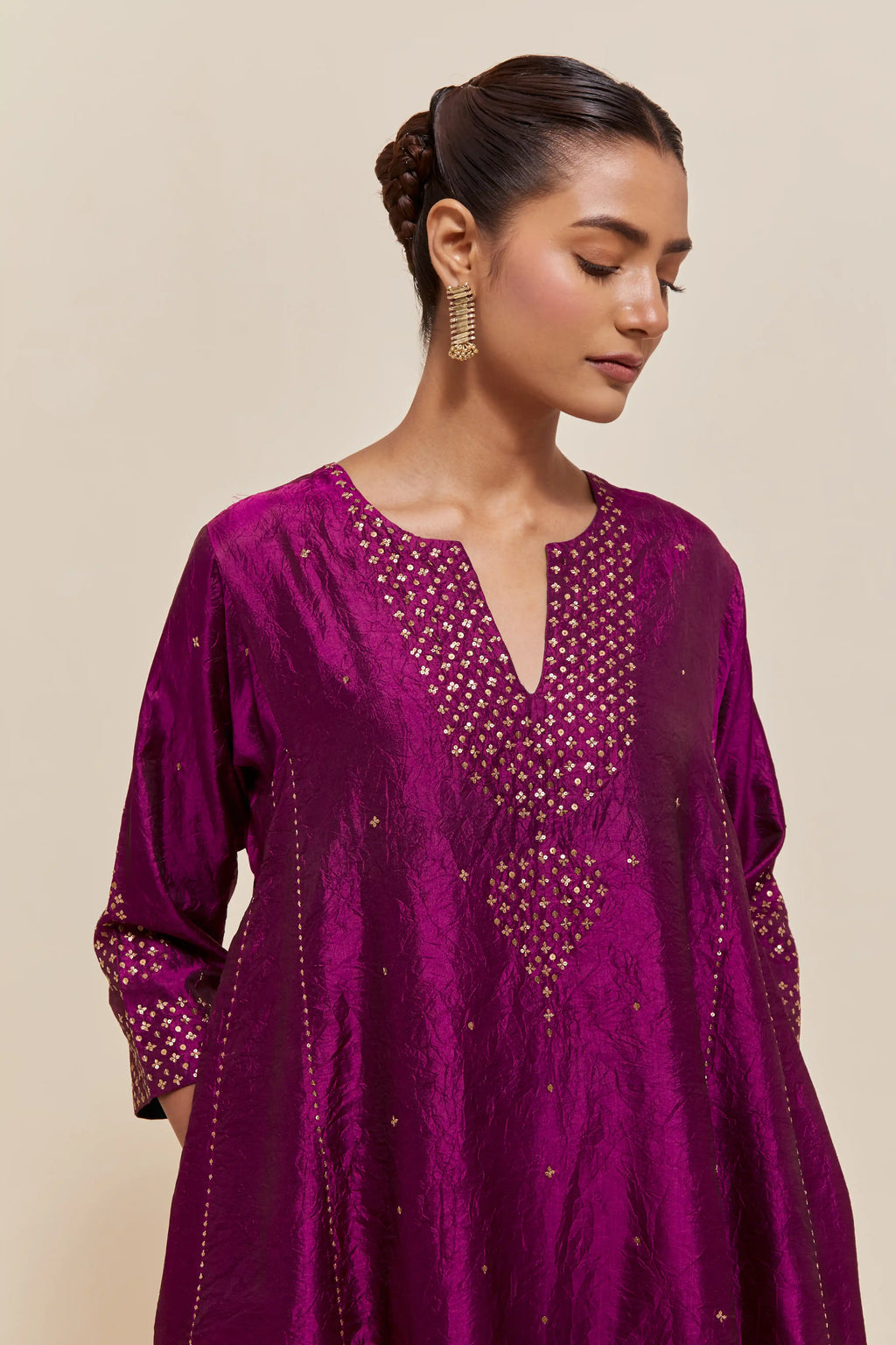 Purple silk short kalidar kurta set, with hand embroidered sequins at neck, hem and sleeve edges, highlighted with scattered gold sequins embellishments all-over.