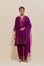 Purple silk short kalidar kurta set, with hand embroidered sequins at neck, hem and sleeve edges, highlighted with scattered gold sequins embellishments all-over.