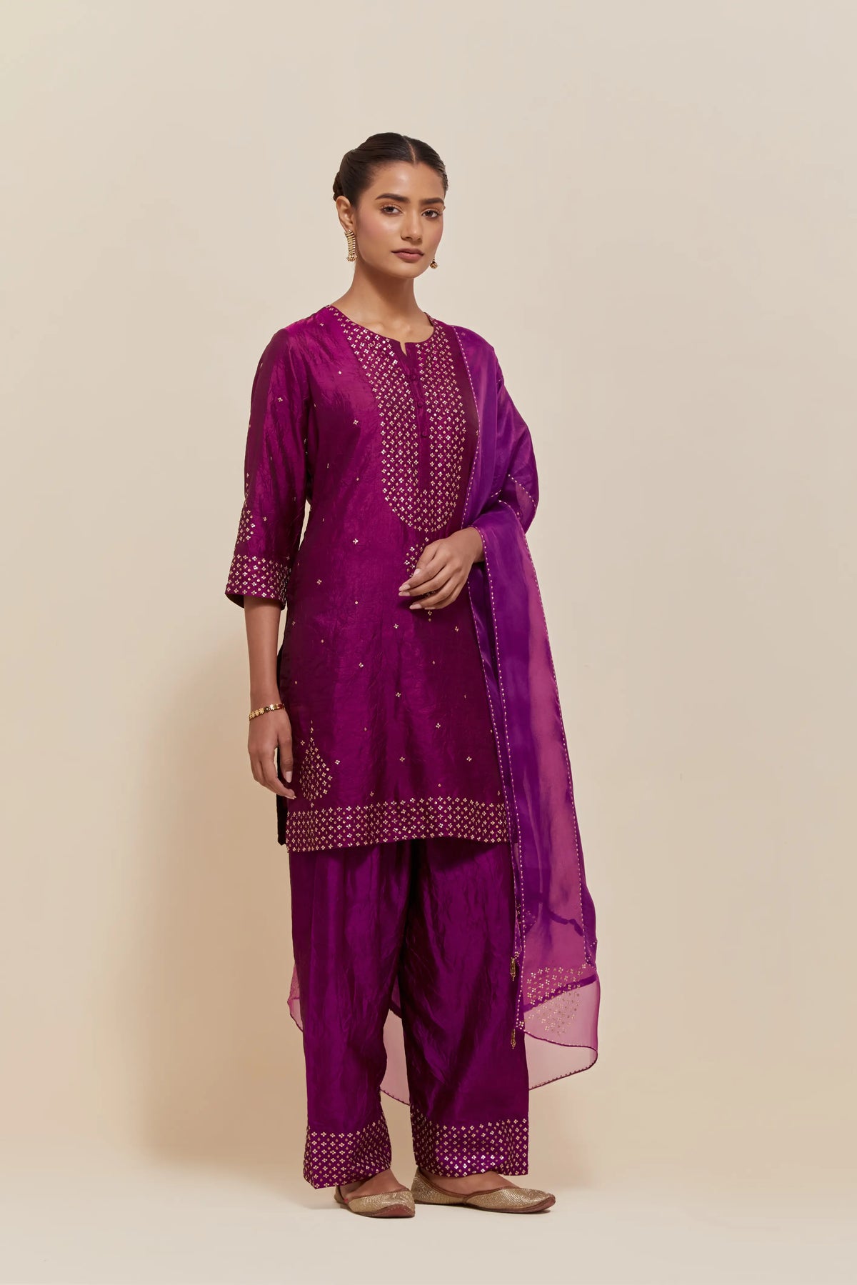 Purple silk straight short kurta set with hand-embroidered sequins at the neck, borders running along the hem and sleeve edges, and scattered gold sequins embellishments all-over.