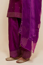 Purple silk straight short kurta set with hand-embroidered sequins at the neck, borders running along the hem and sleeve edges, and scattered gold sequins embellishments all-over.