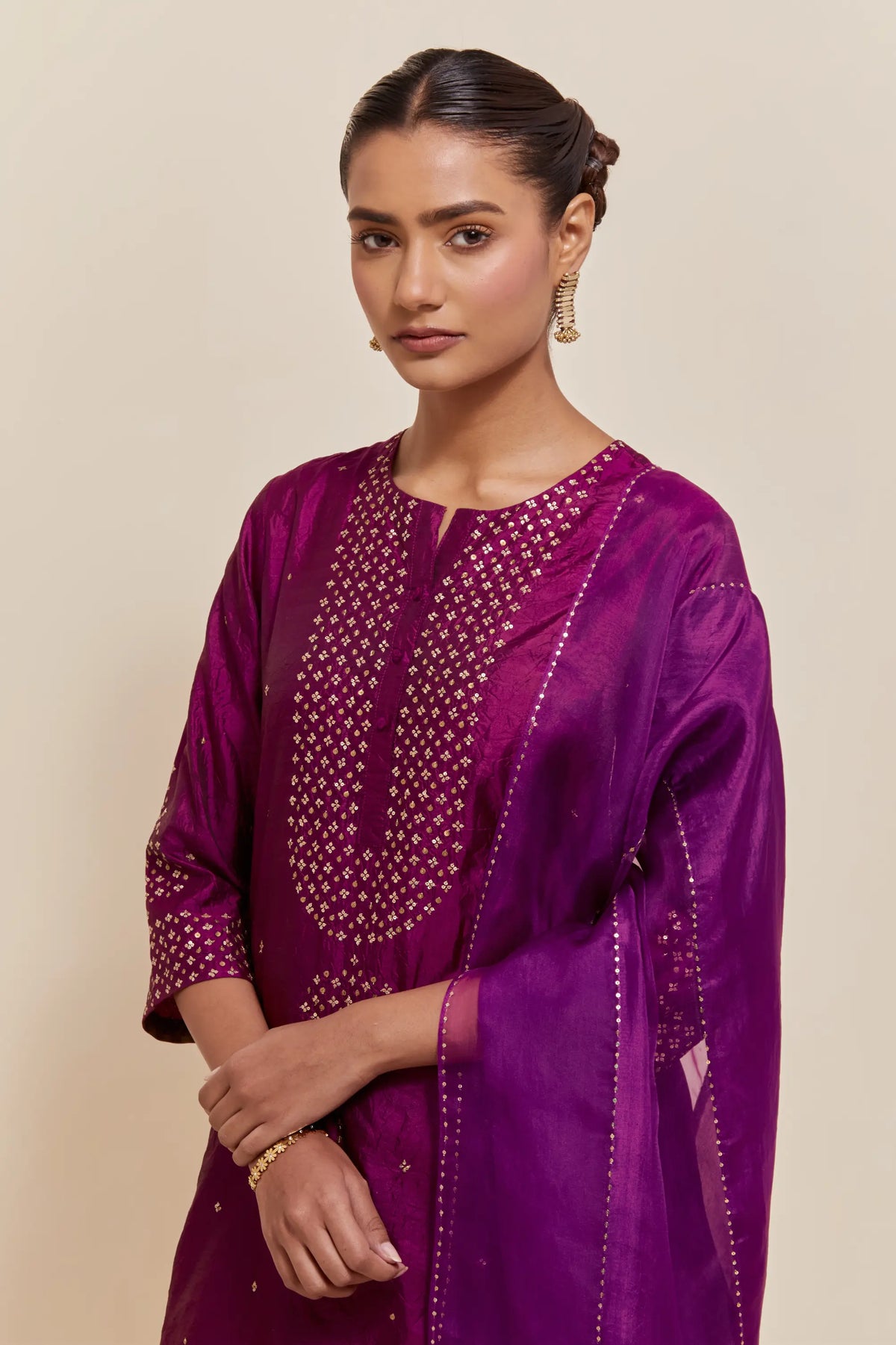 Purple silk straight short kurta set with hand-embroidered sequins at the neck, borders running along the hem and sleeve edges, and scattered gold sequins embellishments all-over.