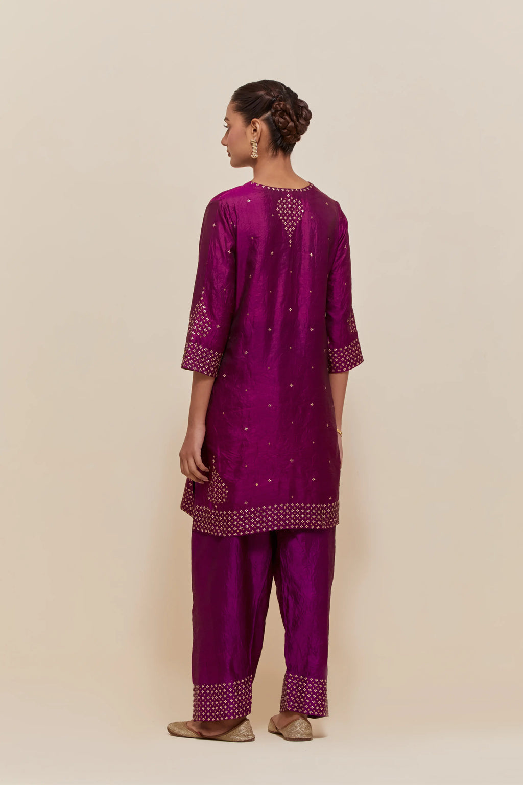 Purple silk straight short kurta set with hand-embroidered sequins at the neck, borders running along the hem and sleeve edges, and scattered gold sequins embellishments all-over.