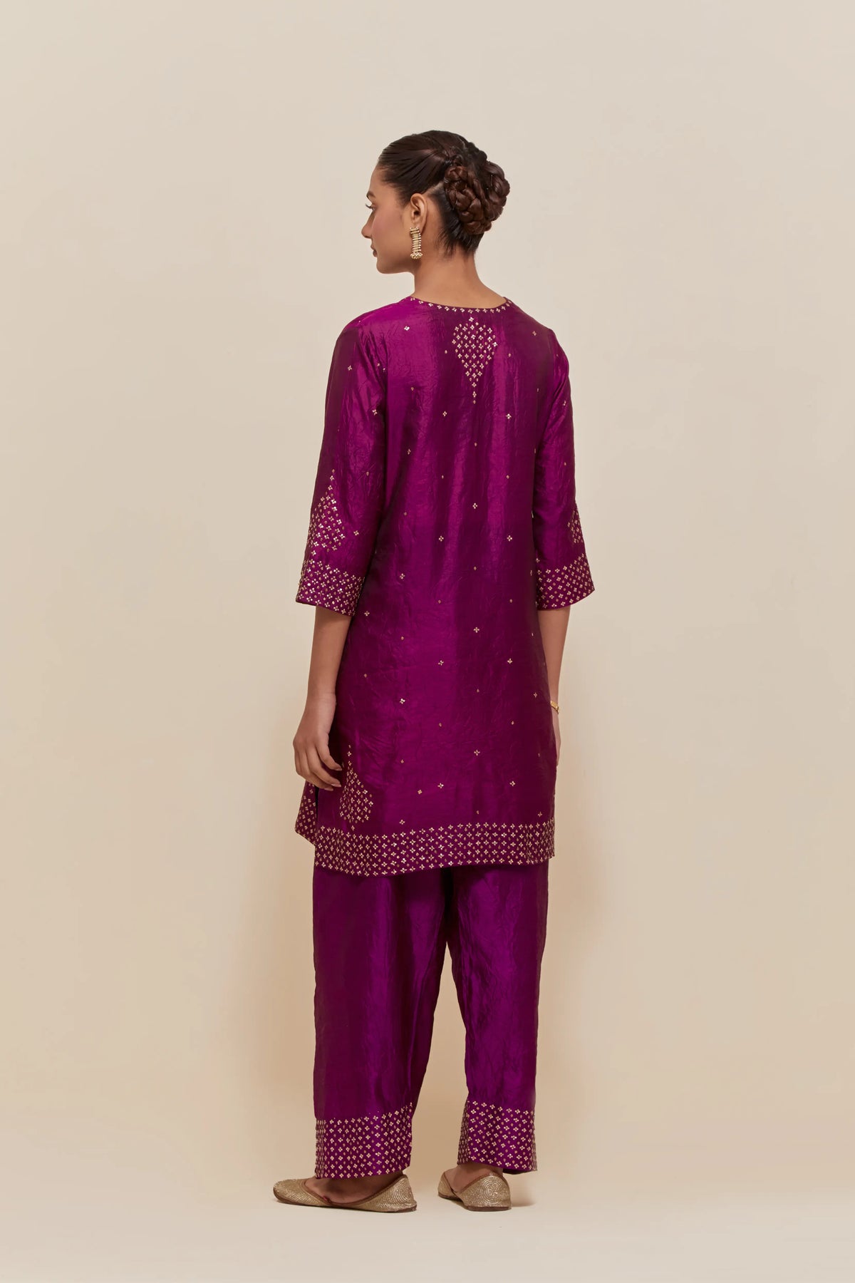Purple silk straight short kurta set with hand-embroidered sequins at the neck, borders running along the hem and sleeve edges, and scattered gold sequins embellishments all-over.