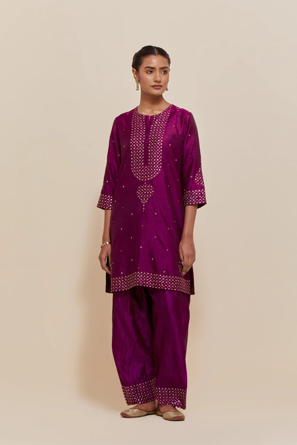 Purple silk straight short kurta set with hand-embroidered sequins at the neck, borders running along the hem and sleeve edges, and scattered gold sequins embellishments all-over.
