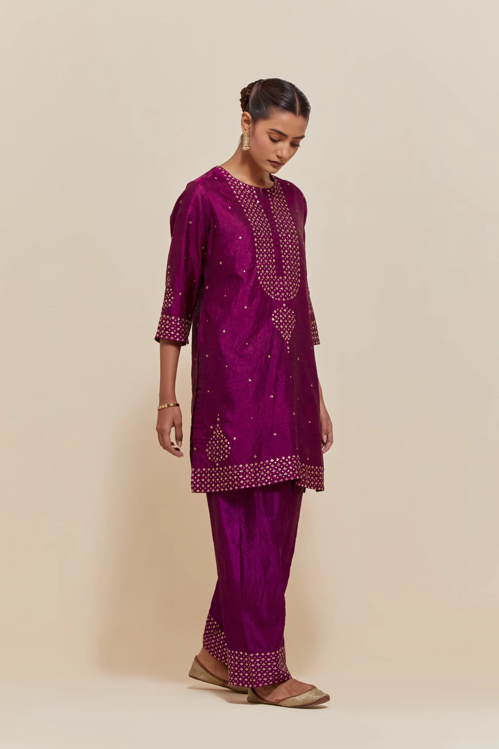 Purple silk straight short kurta set with hand-embroidered sequins at the neck, borders running along the hem and sleeve edges, and scattered gold sequins embellishments all-over.