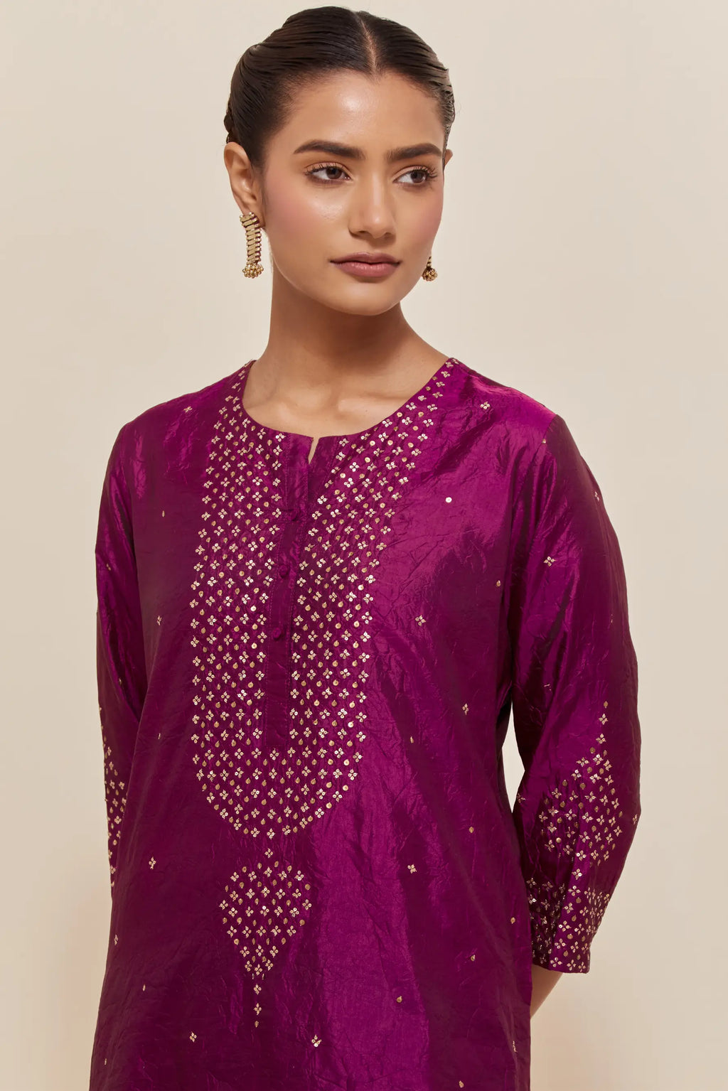 Purple silk straight short kurta set with hand-embroidered sequins at the neck, borders running along the hem and sleeve edges, and scattered gold sequins embellishments all-over.