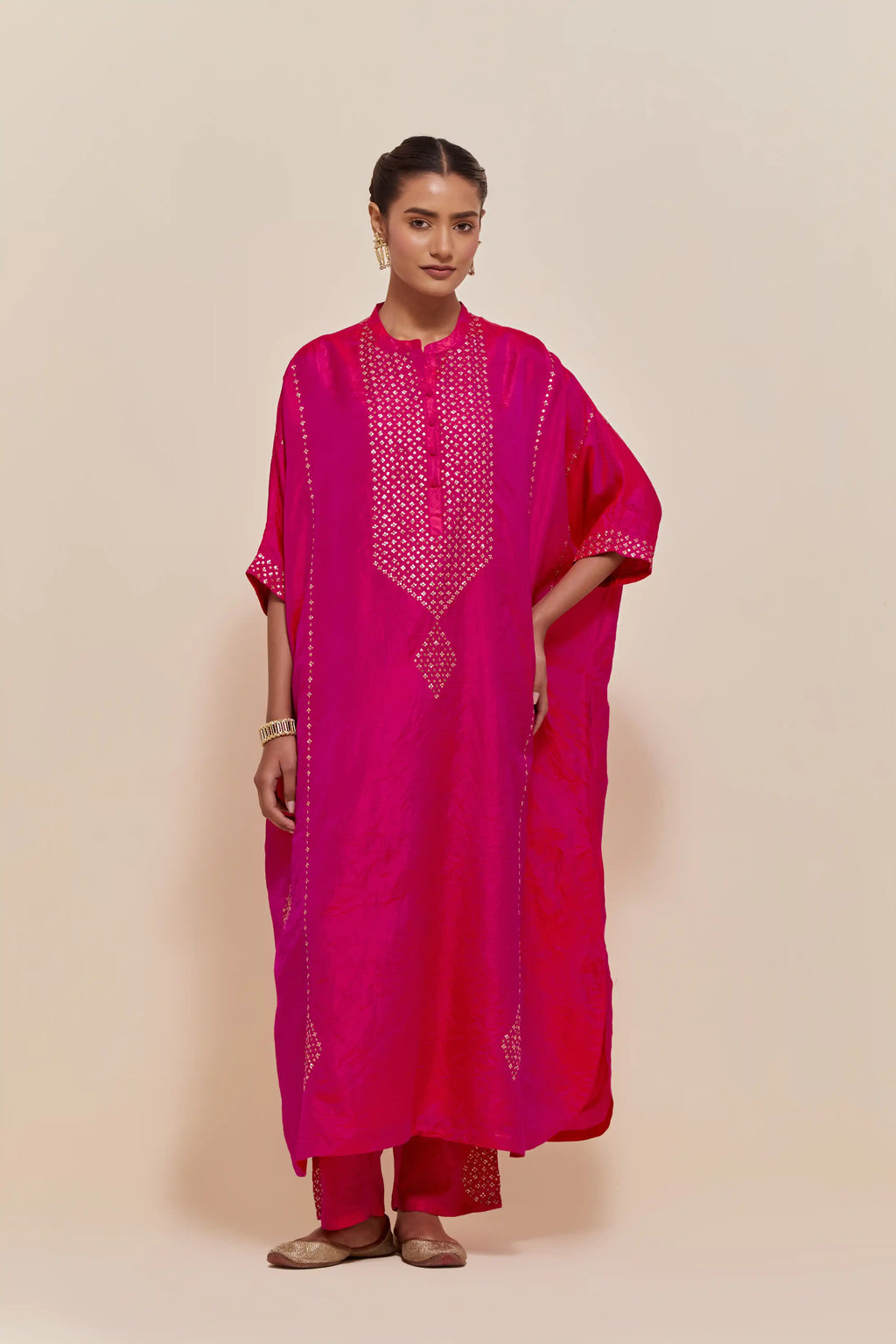Fuchsia silk long kaftan with hand-embroidered sequins at the neck and diamond motifs along the sides, paired with Fuchsia Silk pants with hand embroidered leaf motifs with delicate sequins work at hem.