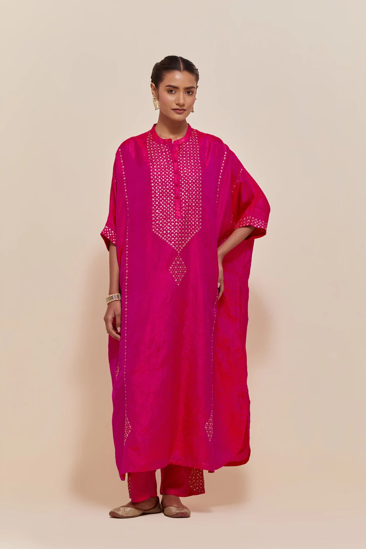 Fuchsia silk long kaftan with hand-embroidered sequins at the neck and diamond motifs along the sides, paired with Fuchsia Silk pants with hand embroidered leaf motifs with delicate sequins work at hem.
