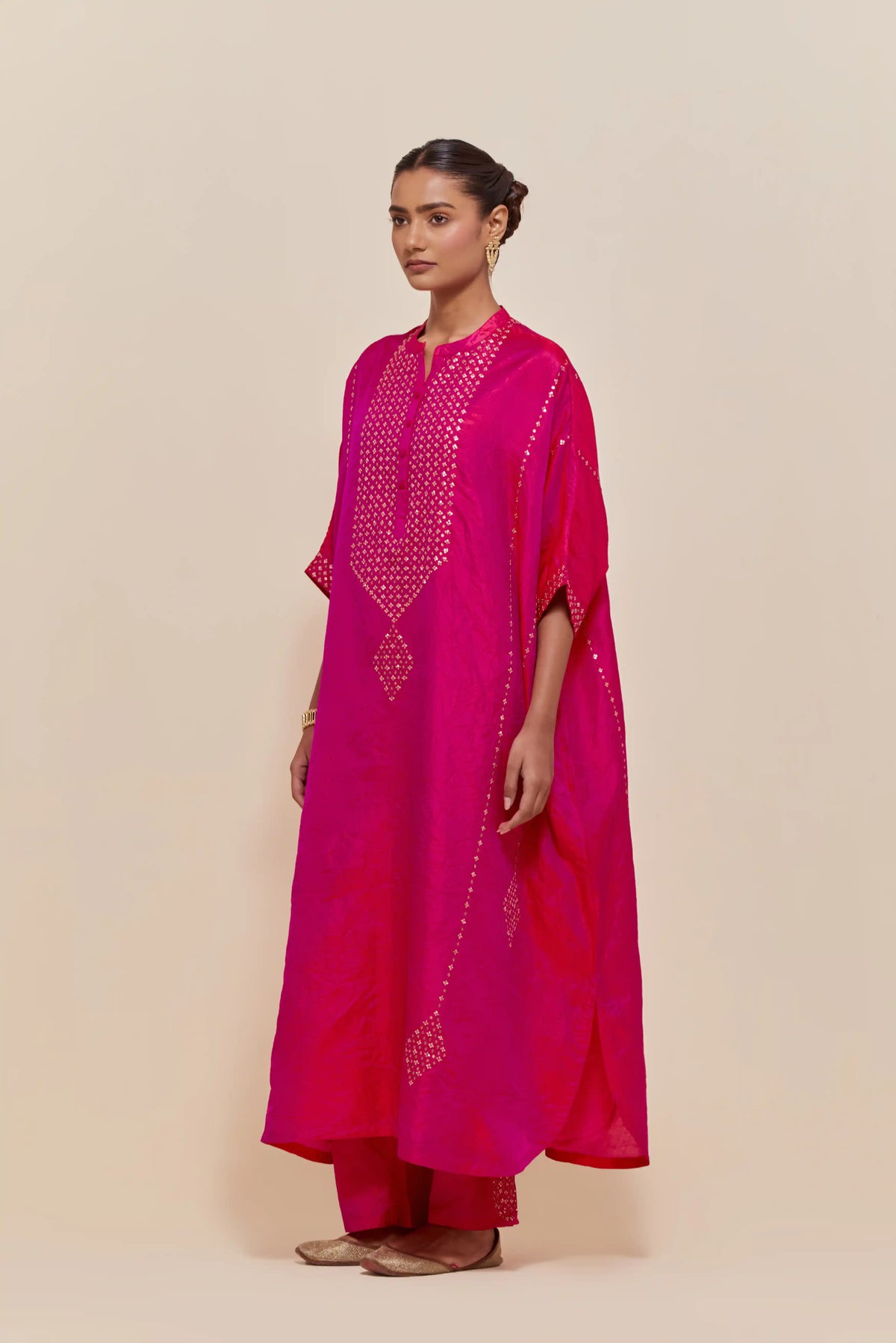 Fuchsia silk long kaftan with hand-embroidered sequins at the neck and diamond motifs along the sides, paired with Fuchsia Silk pants with hand embroidered leaf motifs with delicate sequins work at hem.