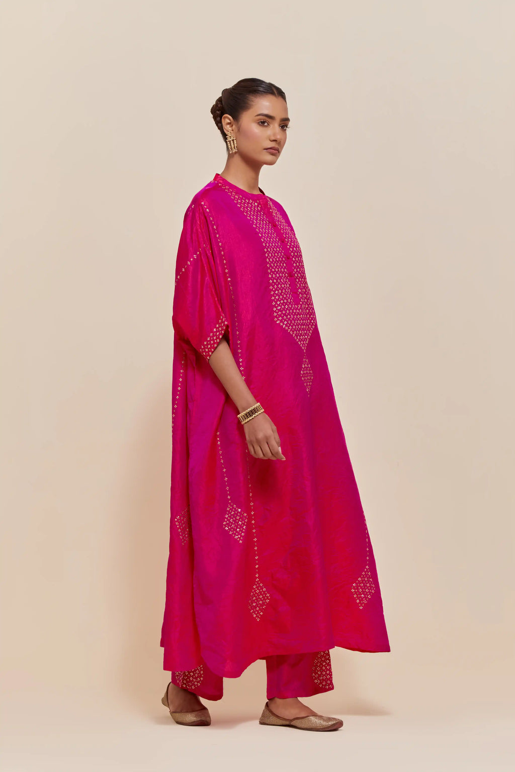Fuchsia silk long kaftan with hand-embroidered sequins at the neck and diamond motifs along the sides, paired with Fuchsia Silk pants with hand embroidered leaf motifs with delicate sequins work at hem.