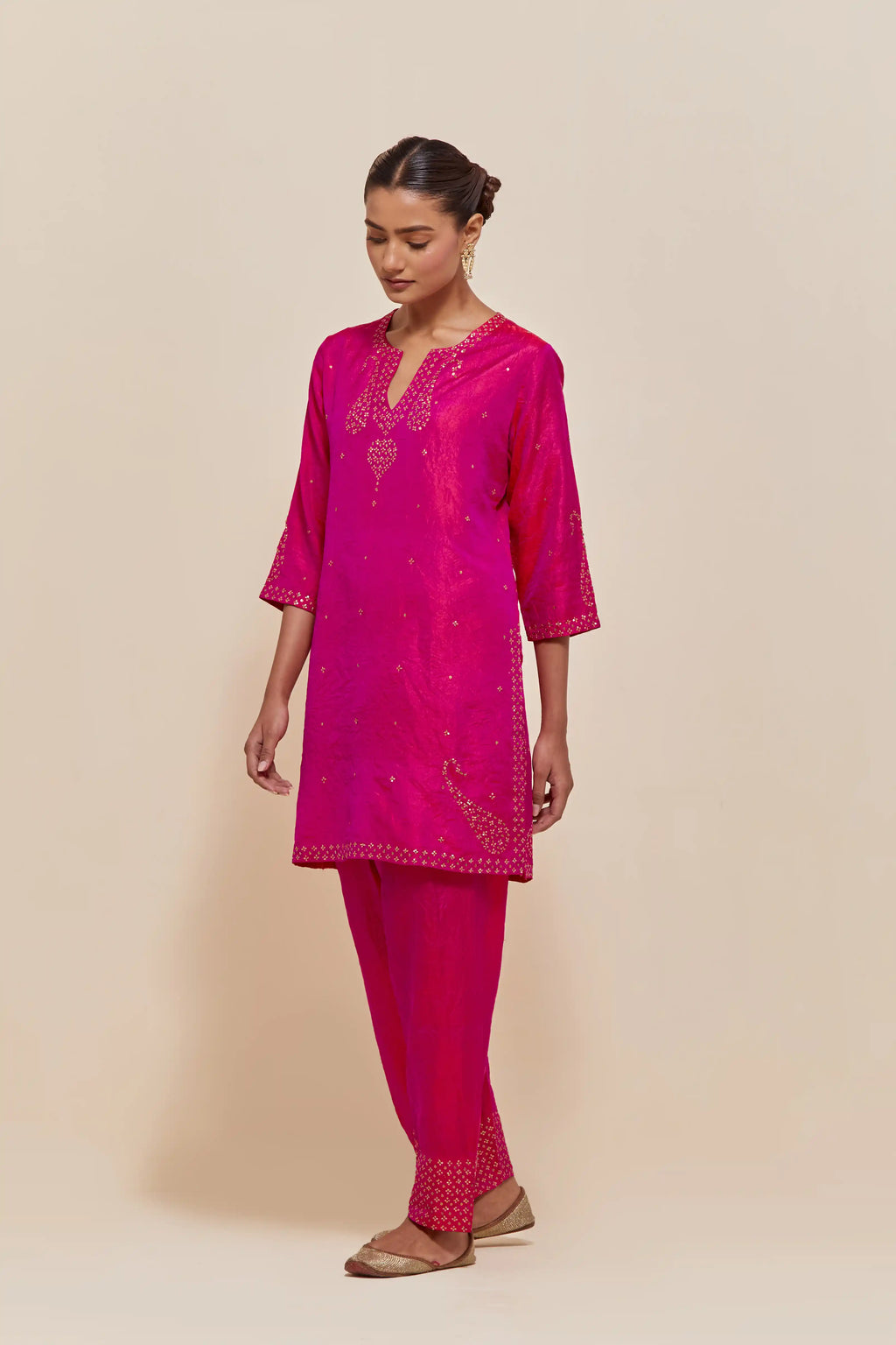 Fuchsia silk straight short kurta set with hand-embroidered paisley motifs with delicate sequins work at neck, hem, and sleeves, with narrow borders along the edges.