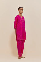 Fuchsia silk straight short kurta set with hand-embroidered paisley motifs with delicate sequins work at neck, hem, and sleeves, with narrow borders along the edges.