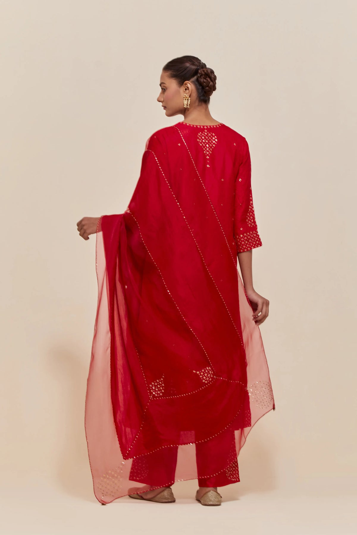 Red silk dupatta with silk organza at the sides, highlighted with hand-embroidered gold sequins work.