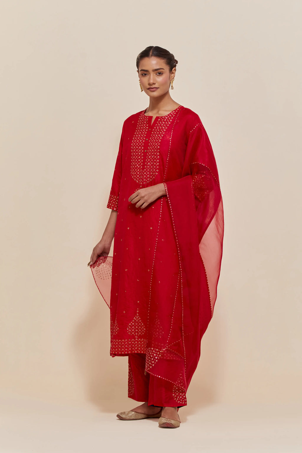 Red silk dupatta with silk organza at the sides, highlighted with hand-embroidered gold sequins work.